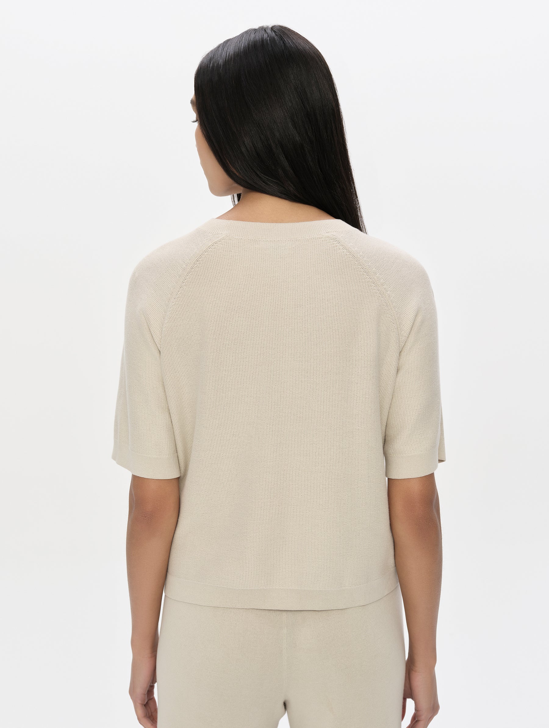 Rear, upper-body view of woman wearing the Eliana Sweater Tee in Bone from AETHER Apparel.
