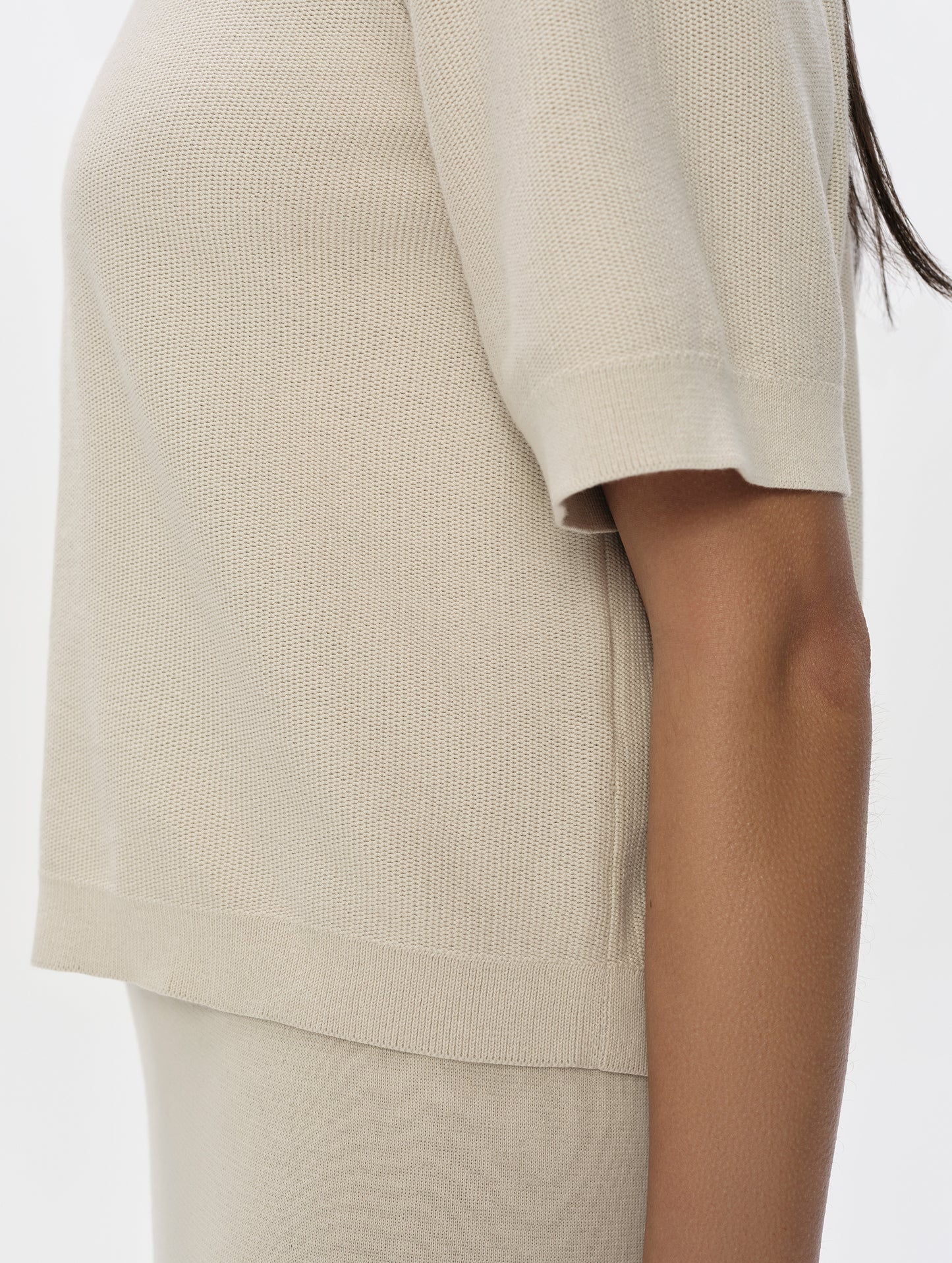 Closeup detailed view of the sleeve and waist hem on the Eliana Sweater Tee in Bone from AETHER Apparel.