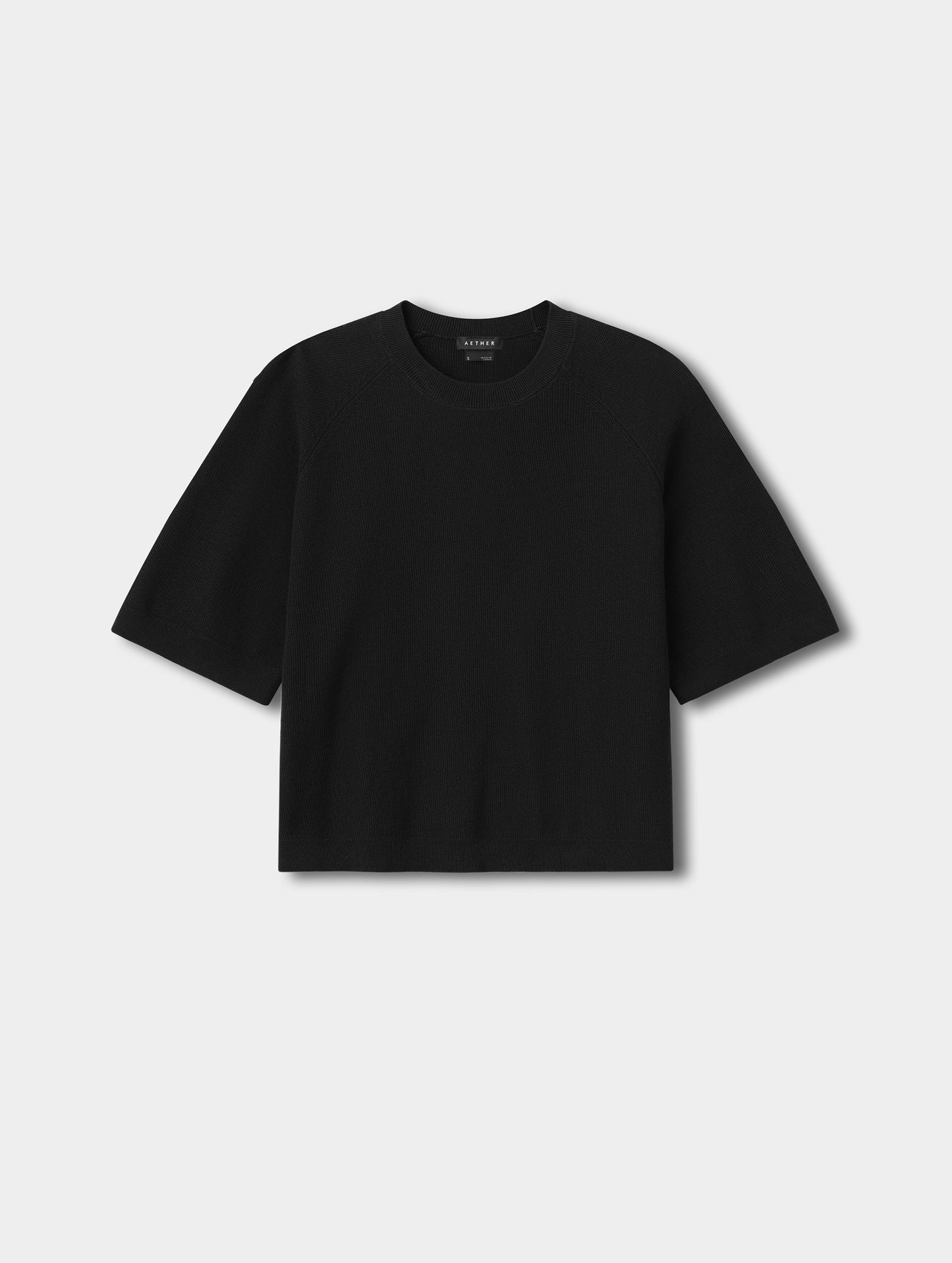 Flat lay view of the Eliana Sweater Tee in Onyx Black from AETHER.
