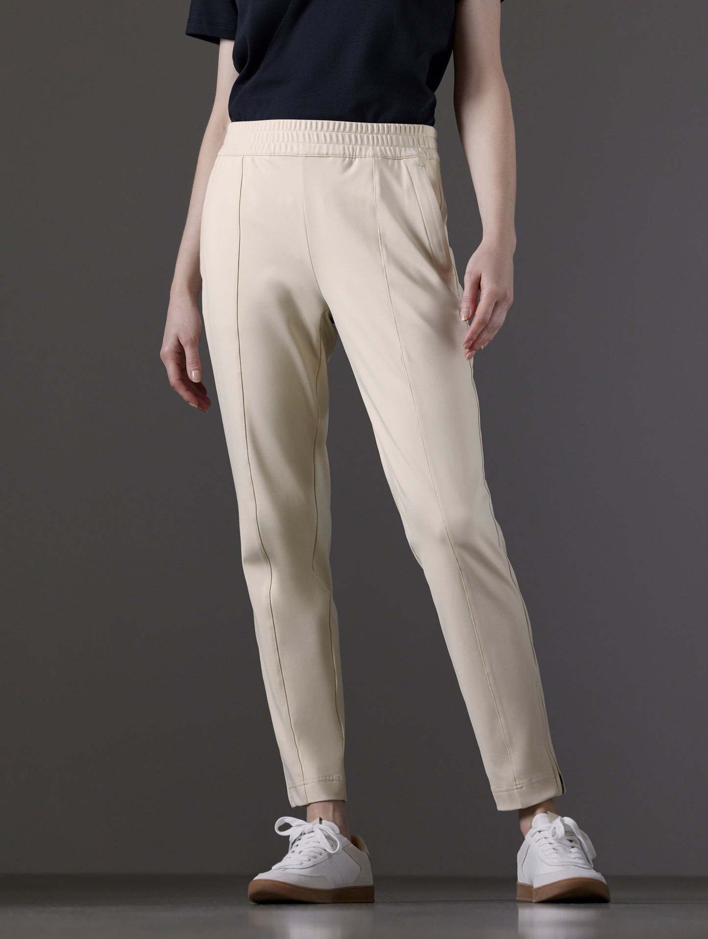 Front lower body view of woman wearing Eloise Travel Slim Pant in Bone white from AETHER Apparel.