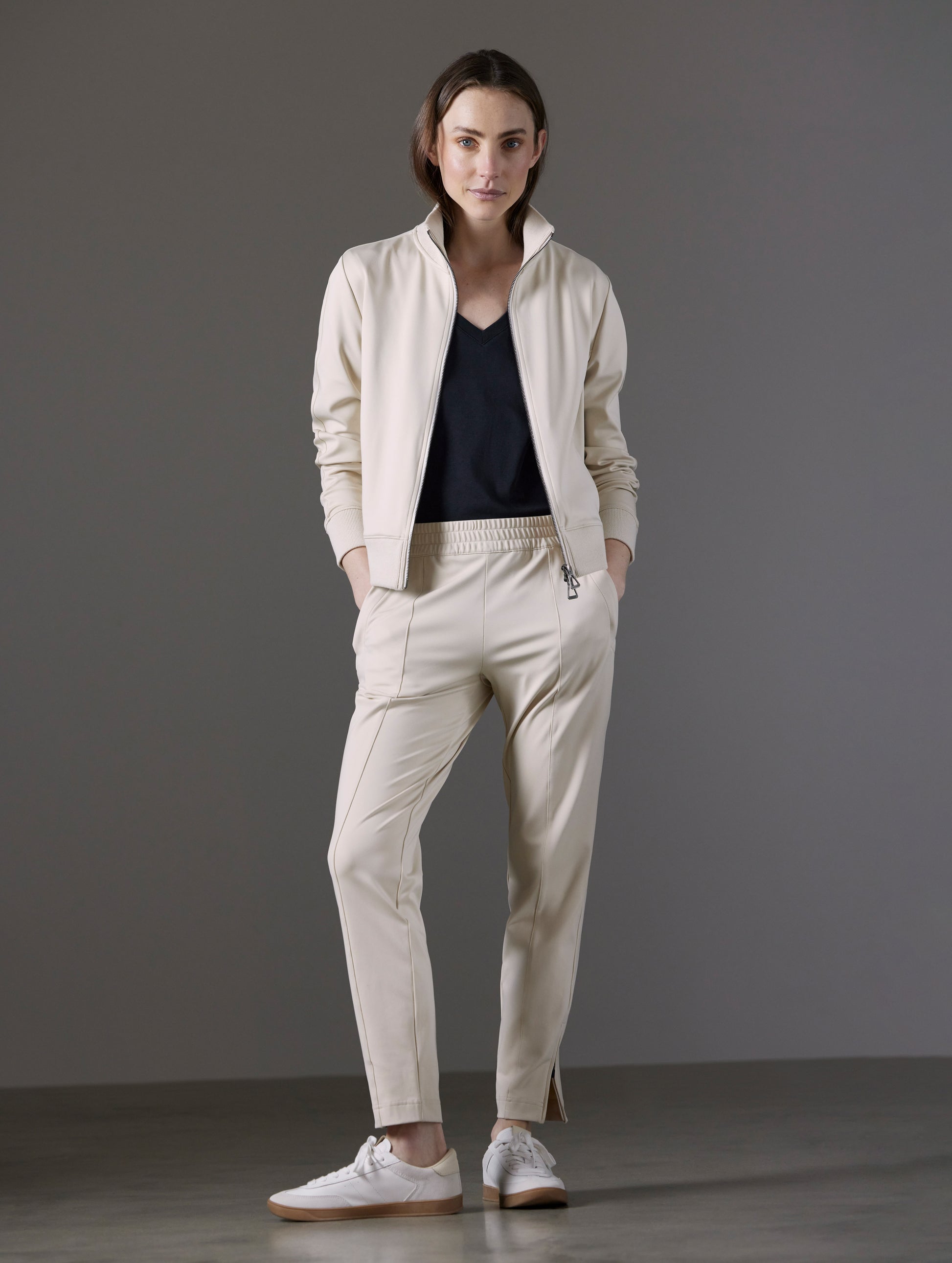 Front full-body view of woman wearing Eloise Travel Slim Pant in Bone white from AETHER Apparel.