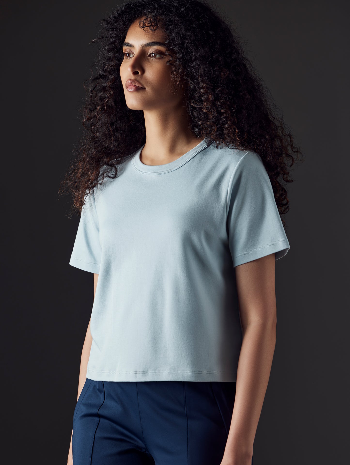 Woman wearing blue organic cropped tee from AETHER Apparel