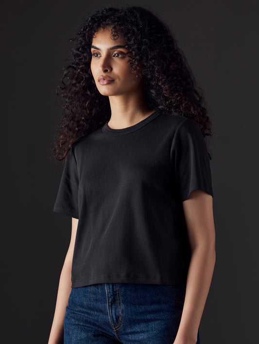 Woman wearing black organic cropped tee from AETHER Apparel