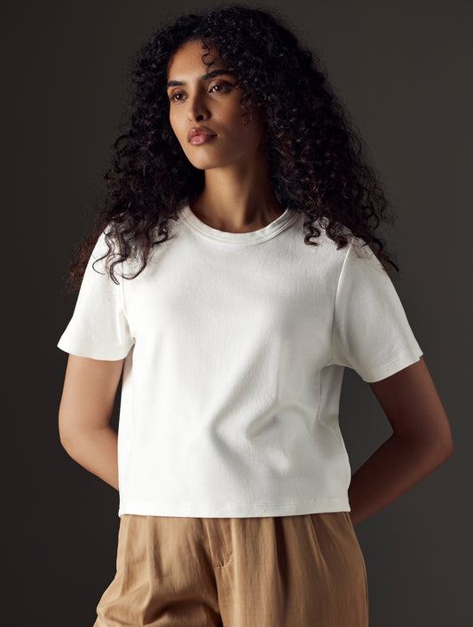 Woman wearing white organic cropped tee from AETHER Apparel
