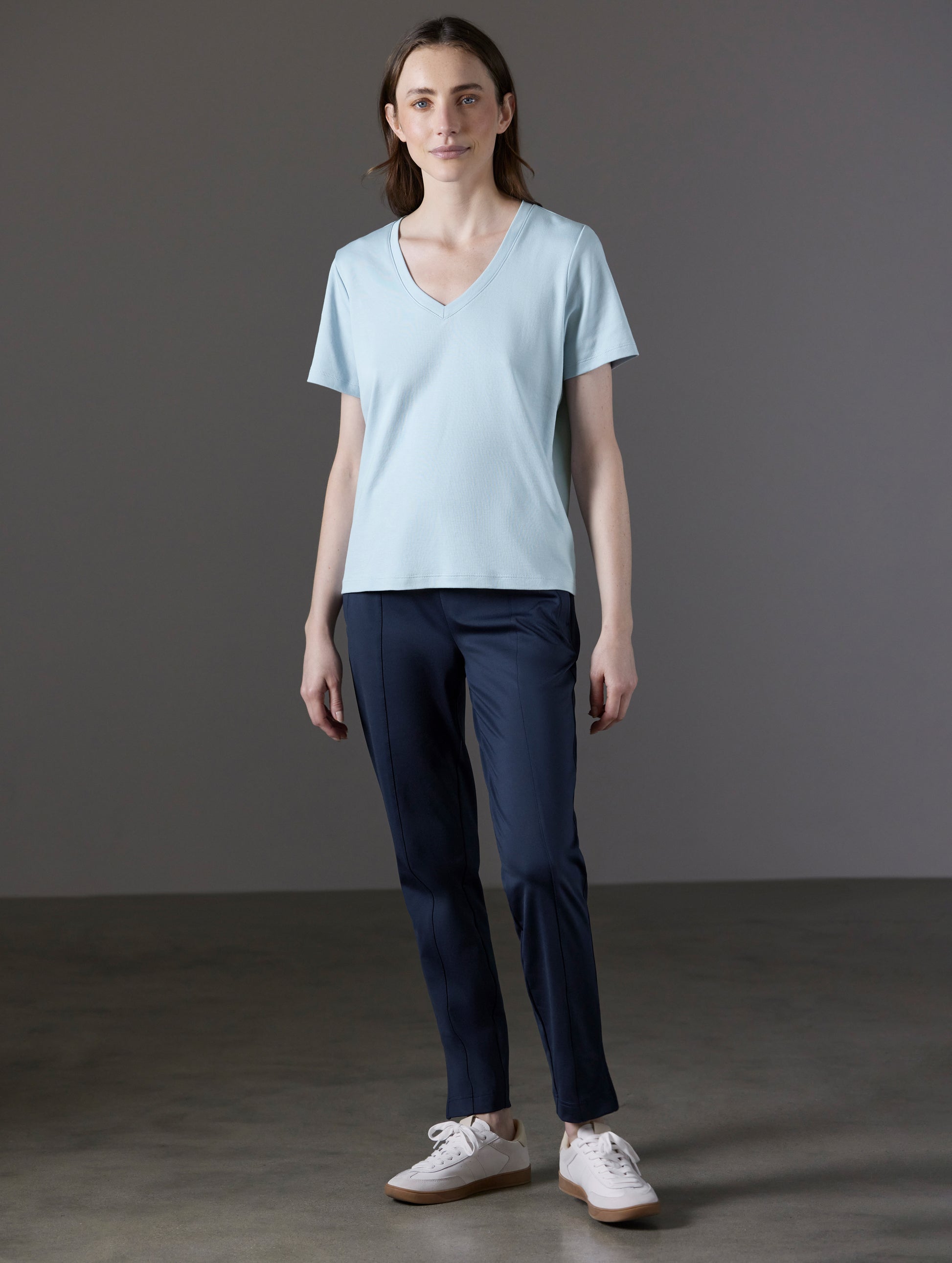 Front full-body view of woman wearing Emery Pima V-Neck Tee in Flight Blue from AETHER Apparel.