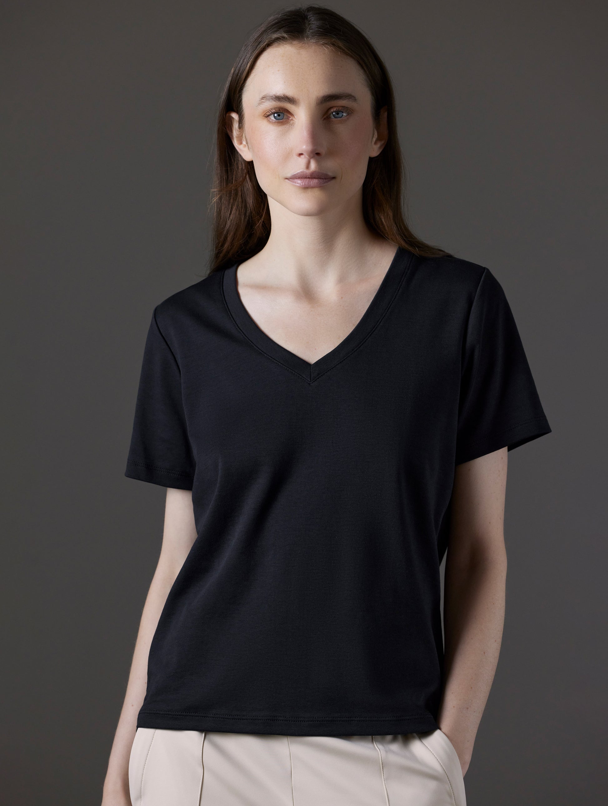 Front view of woman wearing Emery Pima V-Neck Tee in Onyx Black from AETHER Apparel.