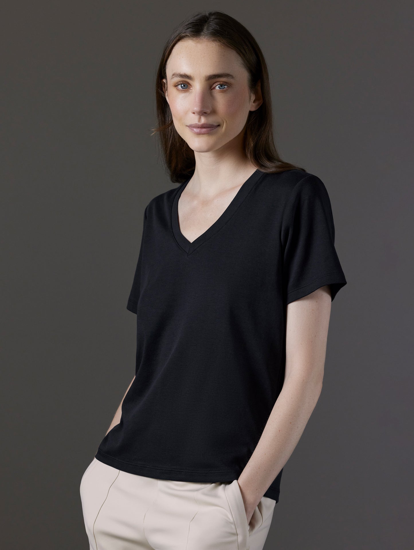 Front angled view of woman wearing Emery Pima V-Neck Tee in Onyx Black from AETHER Apparel.