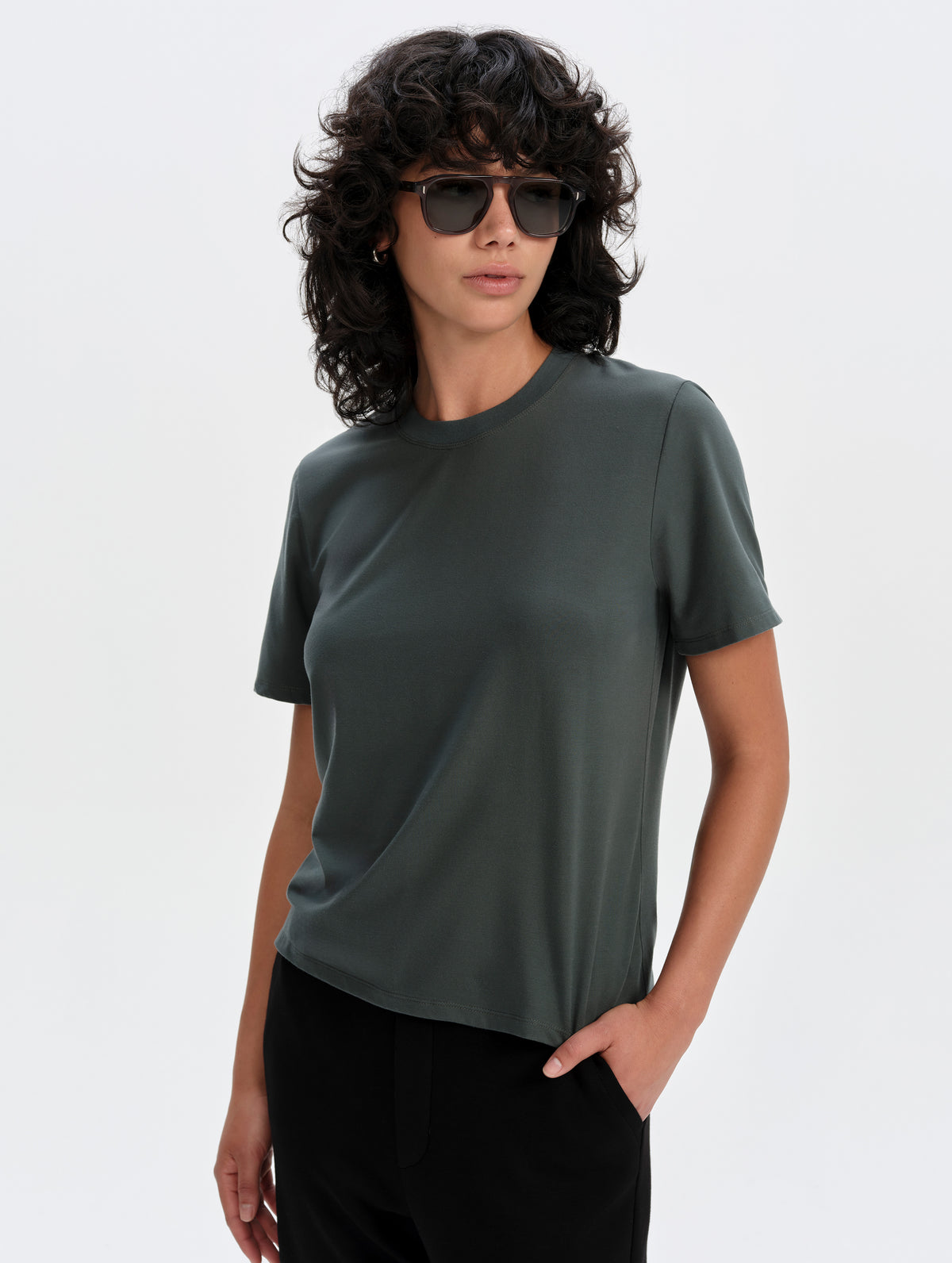 Front upper-body view of woman wearing the Hana Short-Sleeve Tee Shirt in Saville Green from AETHER Apparel.