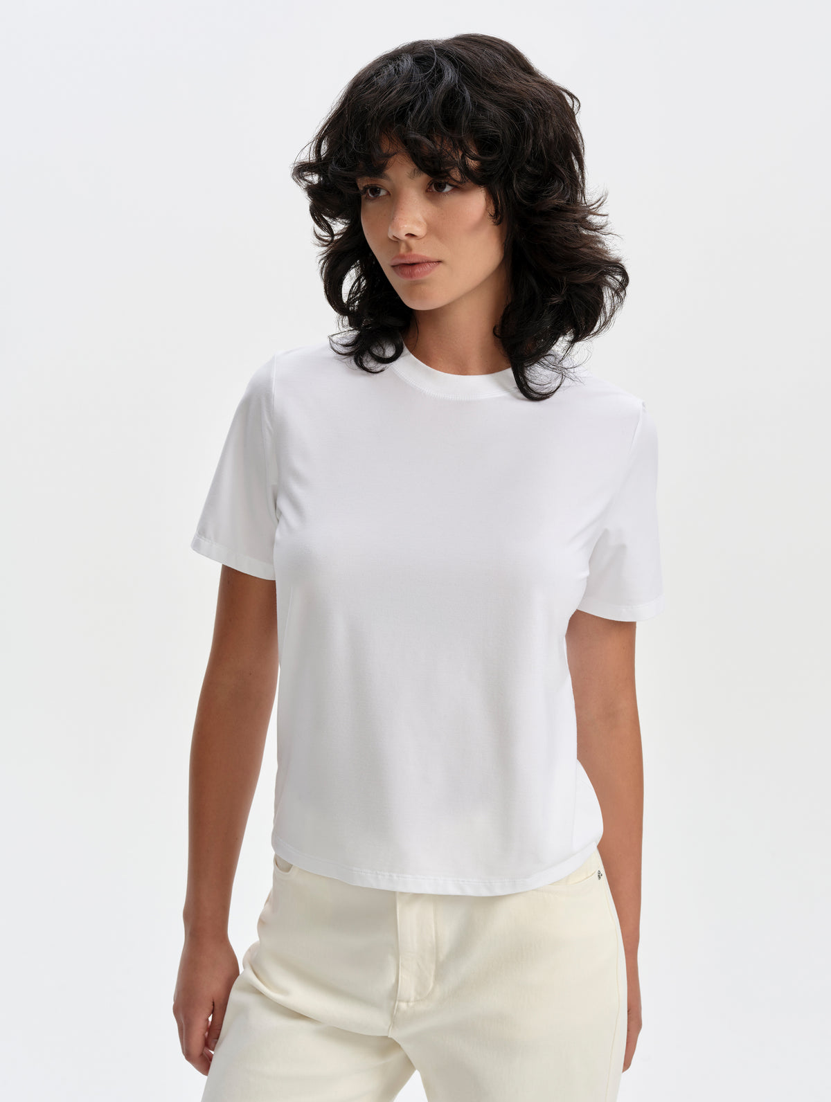 Front upper-body view of woman wearing the Hana Short-Sleeve Tee Shirt in White from AETHER Apparel.