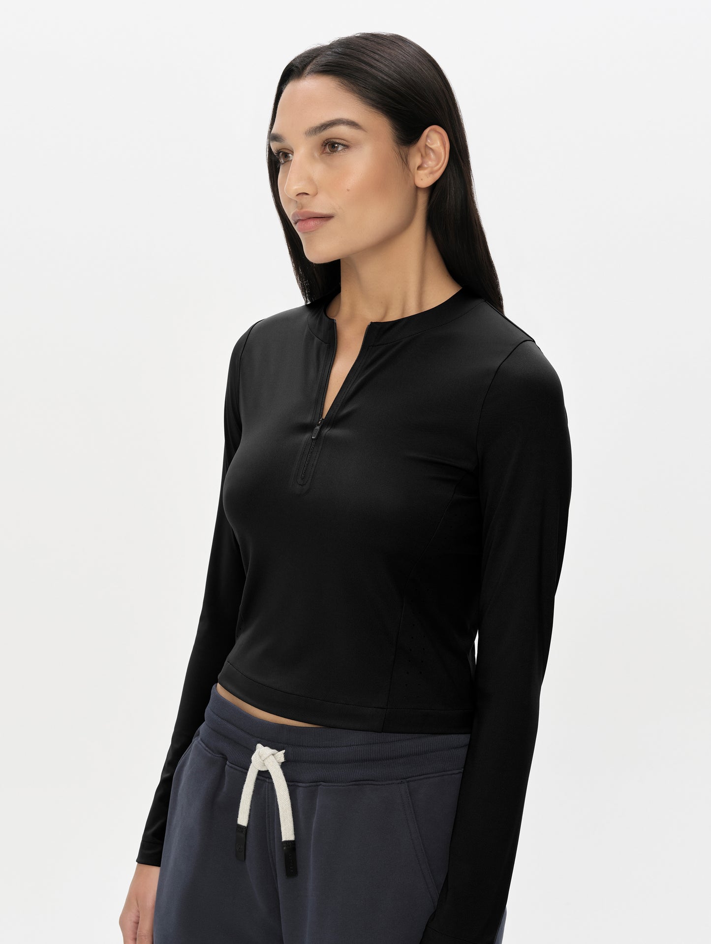 Front, 3/4, upper-body view of woman wearing the Kora Sunproof Shirt in Onyx Black from AETHER Apparel.
