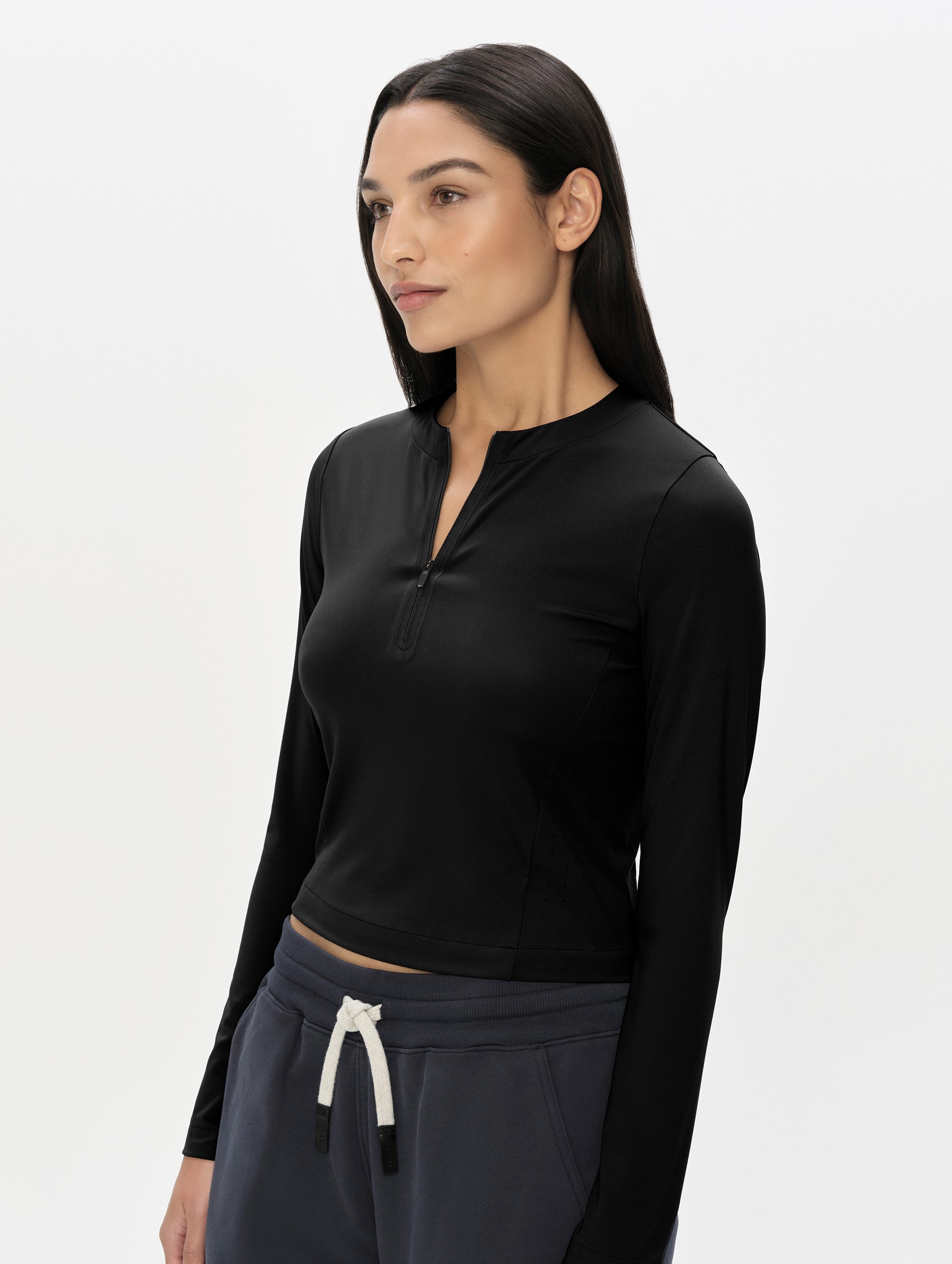 Front, 3/4, upper-body view of woman wearing the Kora Sunproof Shirt in Onyx Black from AETHER Apparel.