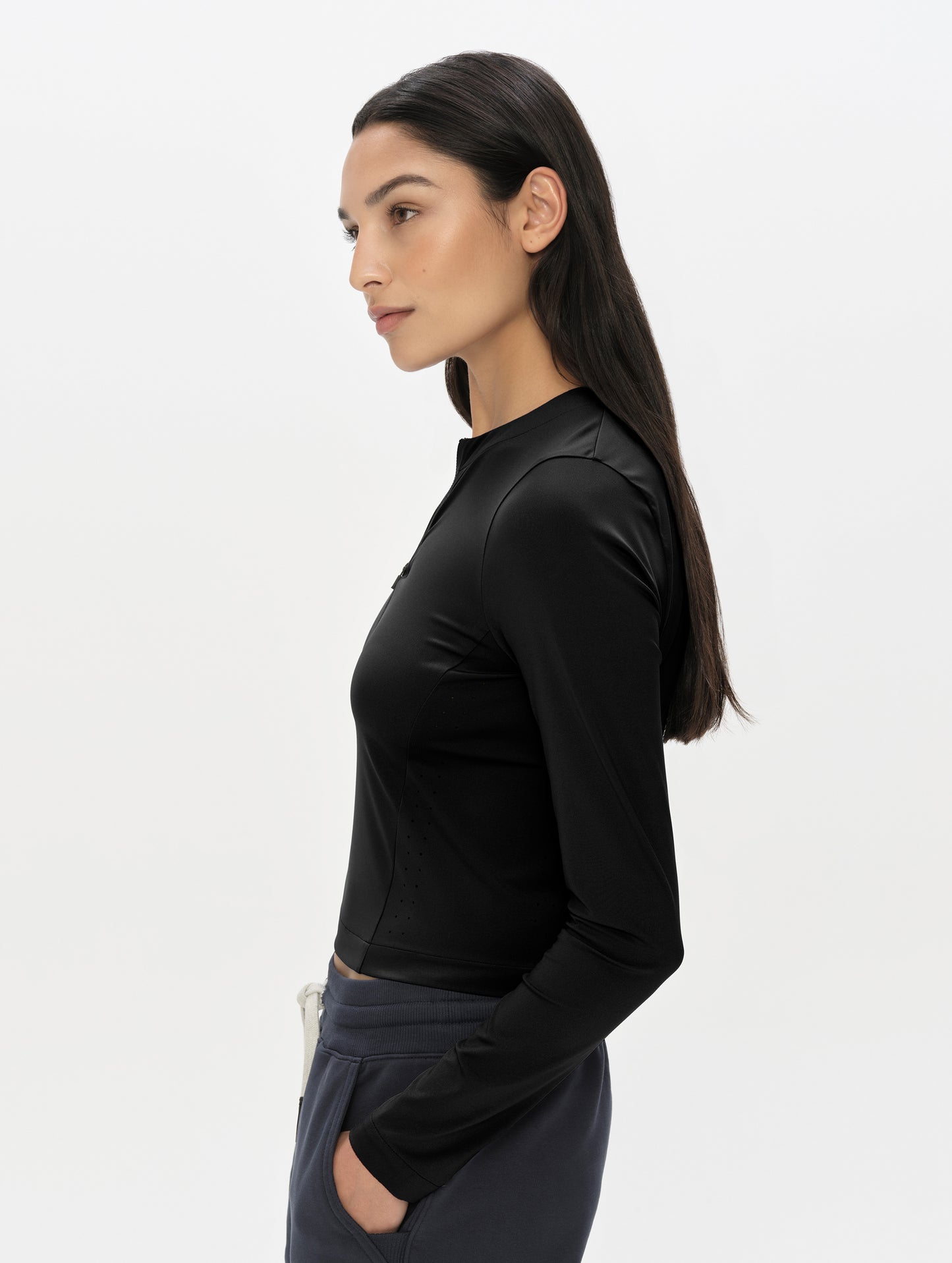 Side profile, upper-body view of woman wearing the Kora Sunproof Shirt in Onyx Black from AETHER Apparel.