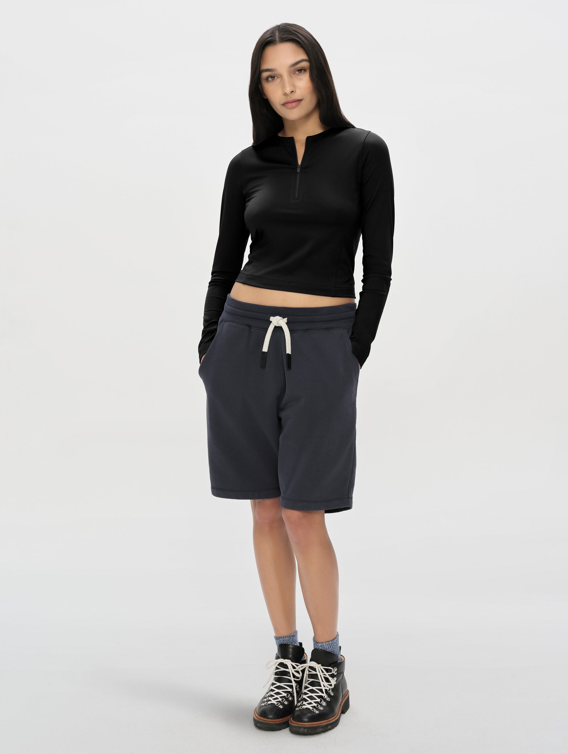 Front, full-body view of woman wearing the Kora Sunproof Shirt in Onyx Black from AETHER Apparel.