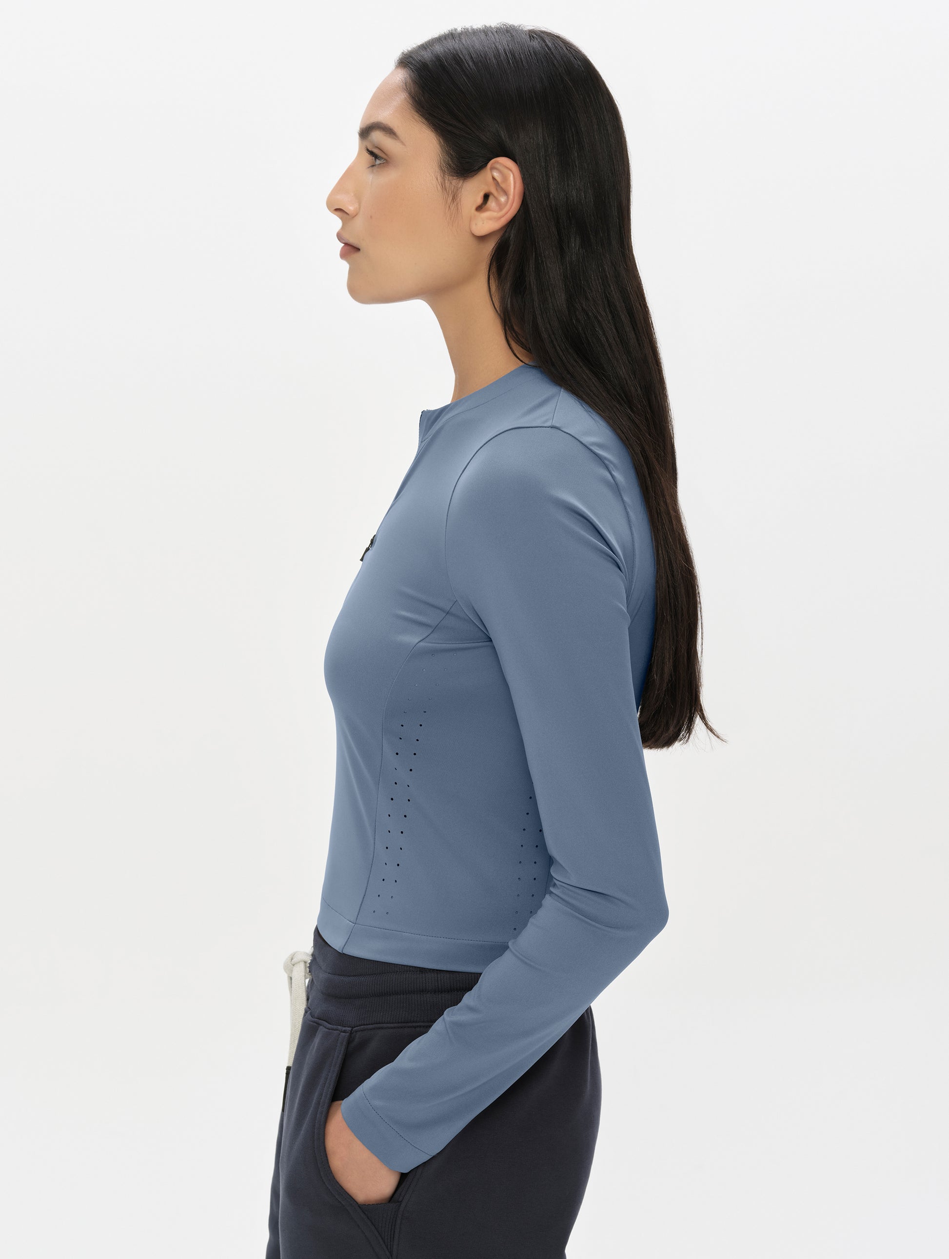 Side profile, upper-body view of woman wearing the Kora Sunproof Shirt in Portal Blue from AETHER Apparel.