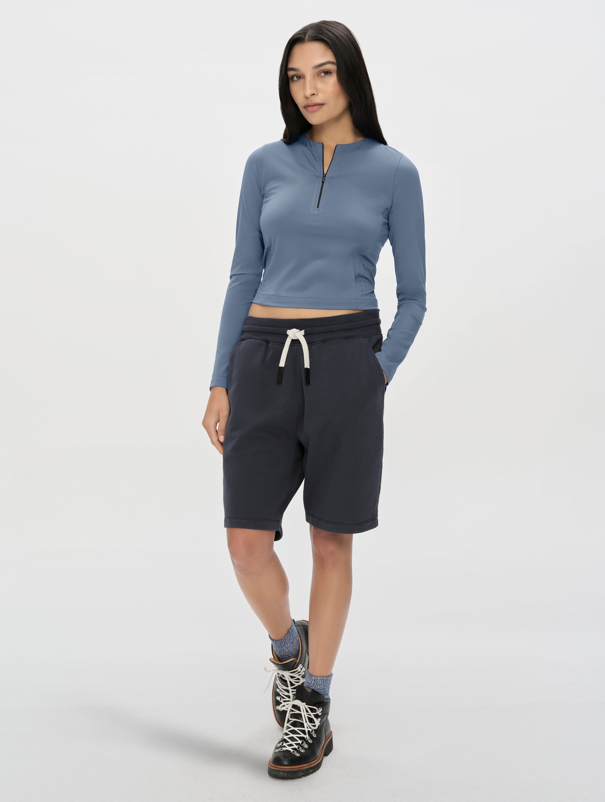 Front, full-body view of woman wearing the Kora Sunproof Shirt in Portal Blue from AETHER Apparel.