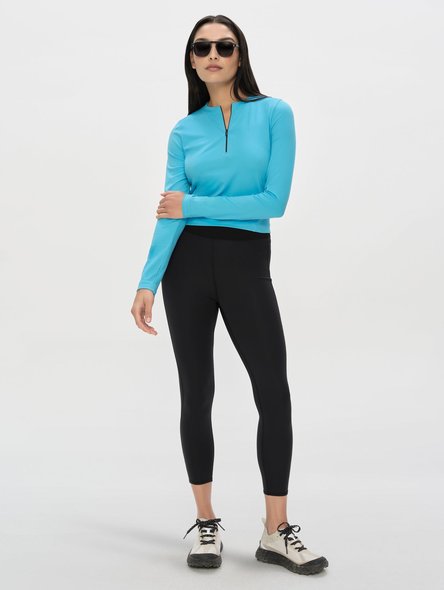 Front, full-body view of woman wearing the Kora Sunproof Shirt in Sky Blue from AETHER Apparel.