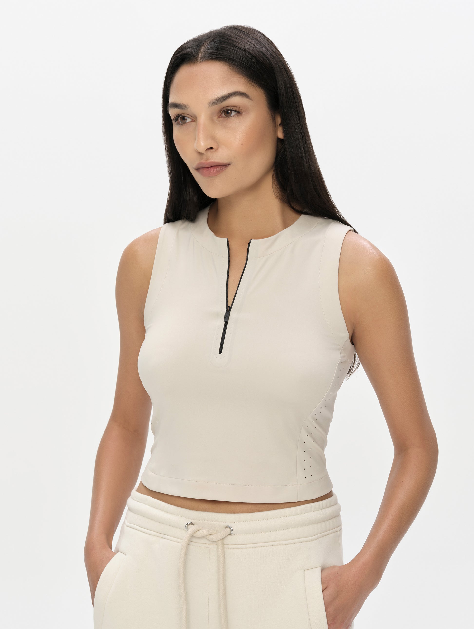 Front, upper-body view of woman wearing the Kora Sunproof Tank Top in Bone from AETHER Apparel.