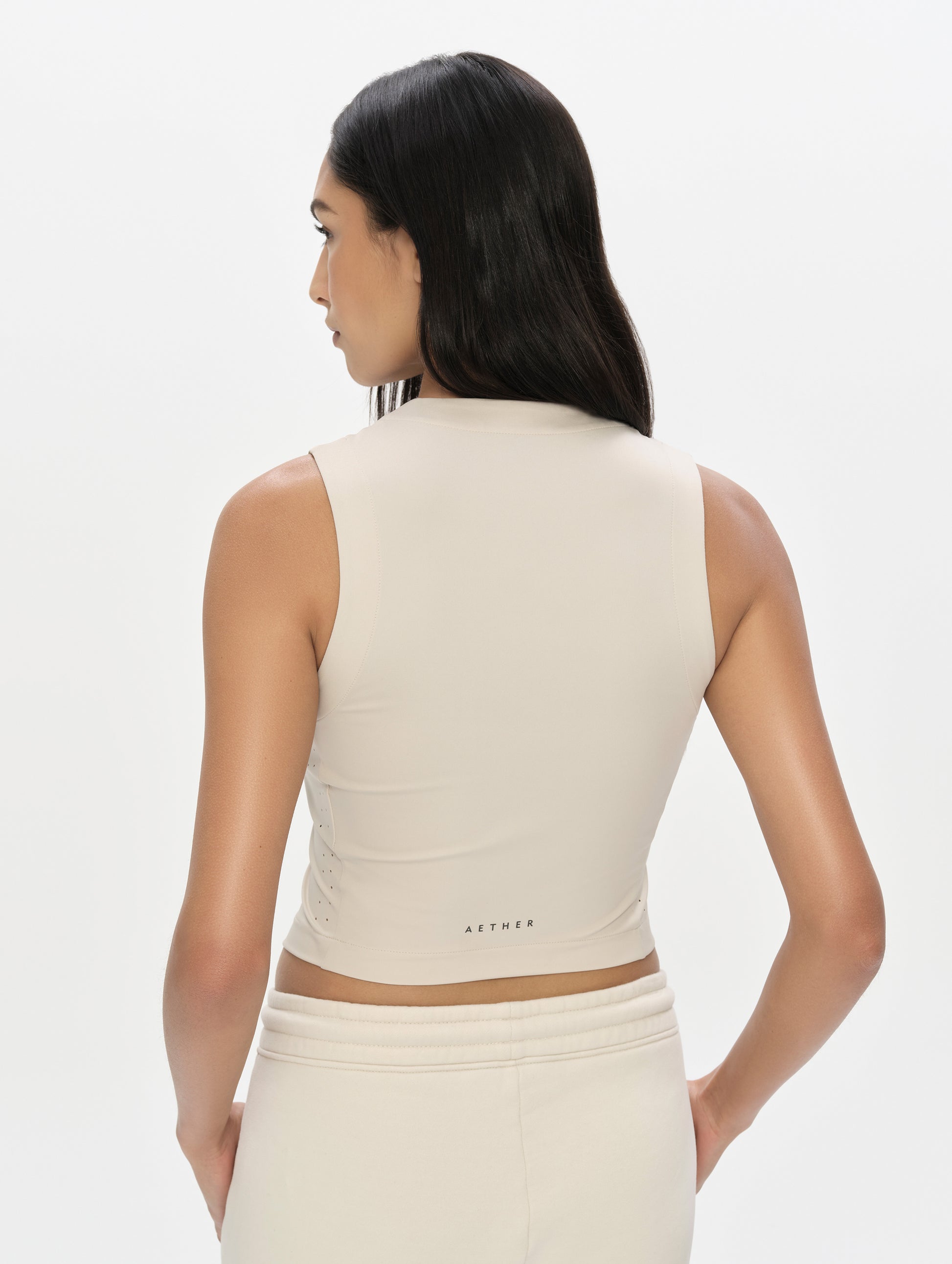 Rear, upper-body view of woman wearing the Kora Sunproof Tank Top in Sky Blue from AETHER Apparel.