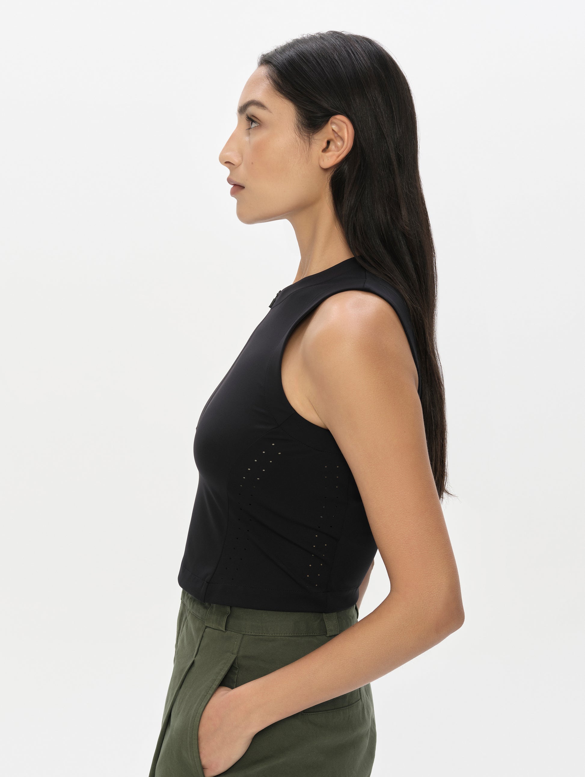 Side profile, upper-body view of woman wearing the Kora Sunproof Tank Top in Onyx Black from AETHER Apparel.