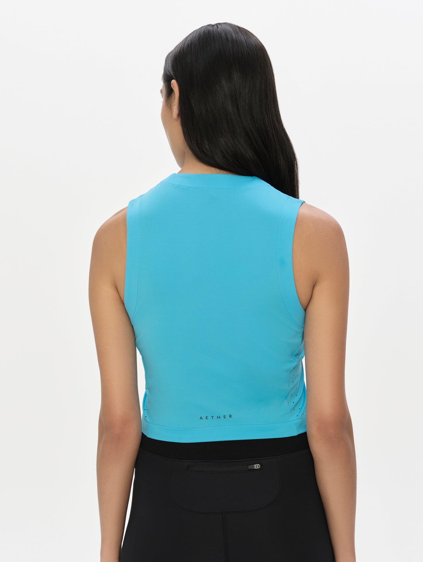 Rear, upper-body view of woman wearing the Kora Sunproof Tank Top in Sky Blue from AETHER Apparel.