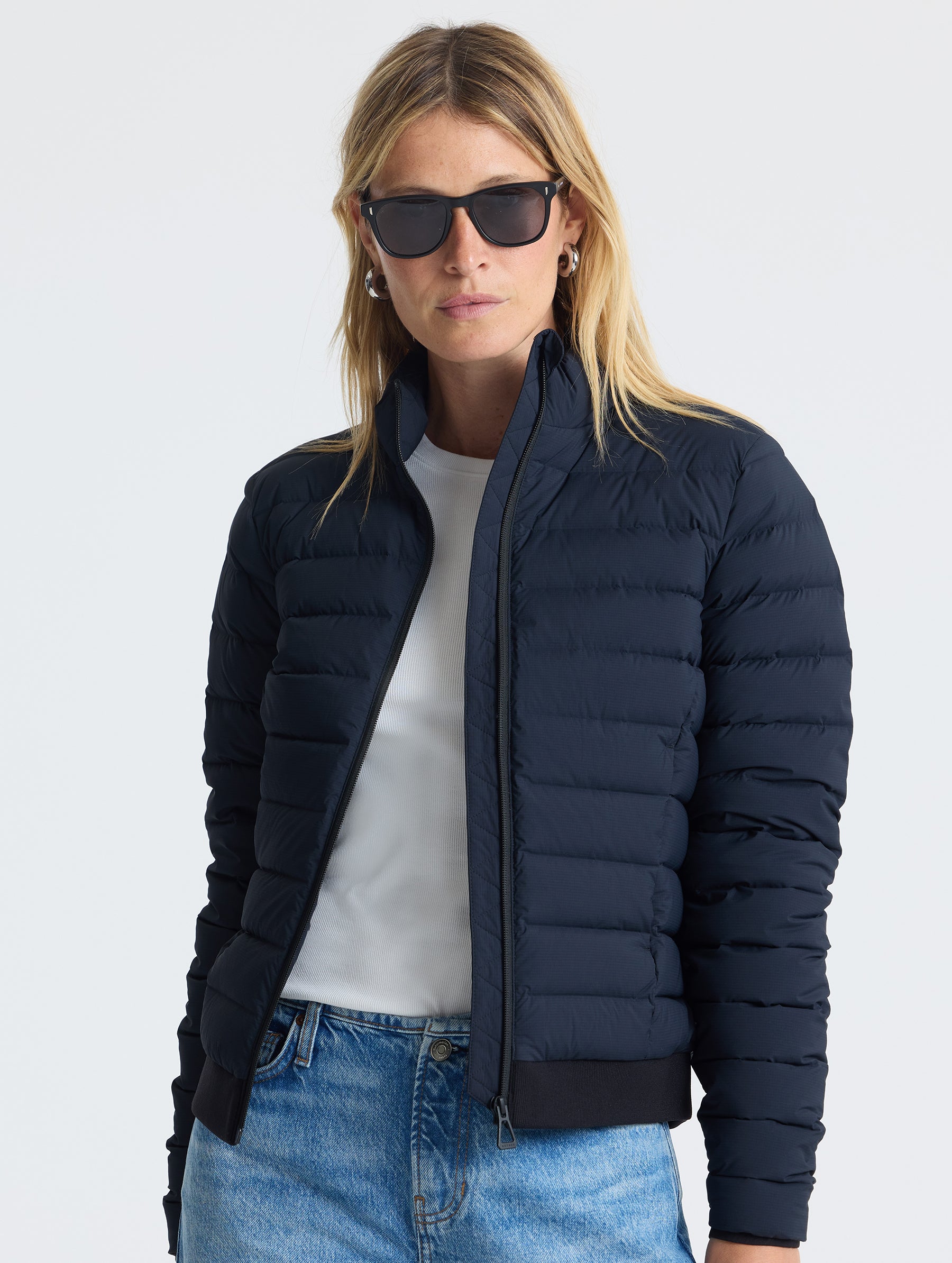 Front view of woman wearing unzipped W Launch Full-Zip Jacket NH in Onyx Black from AETHER Apparel.