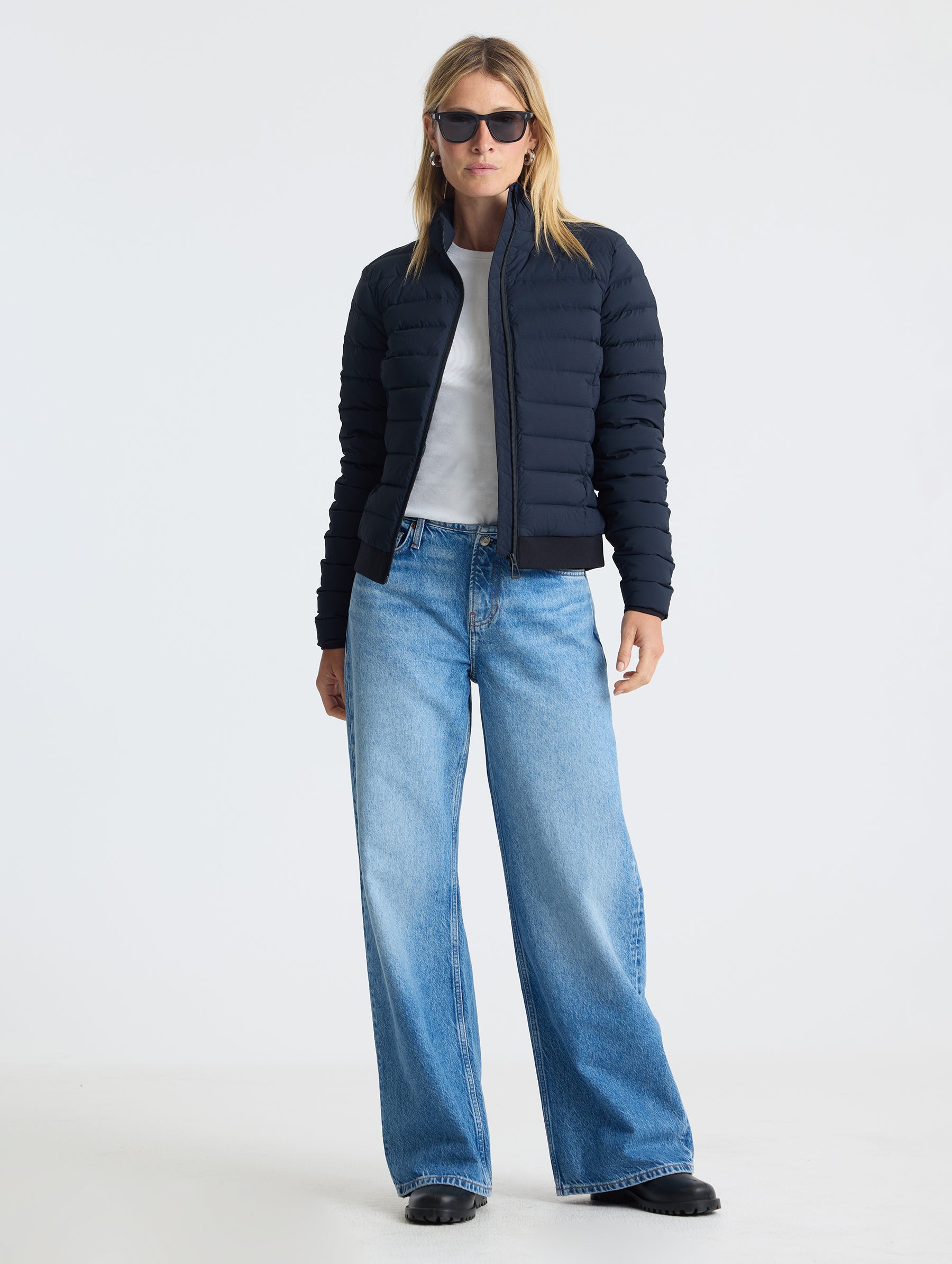 Full body view of woman wearing W Launch Full-Zip Jacket NH in Onyx Black from AETHER Apparel.