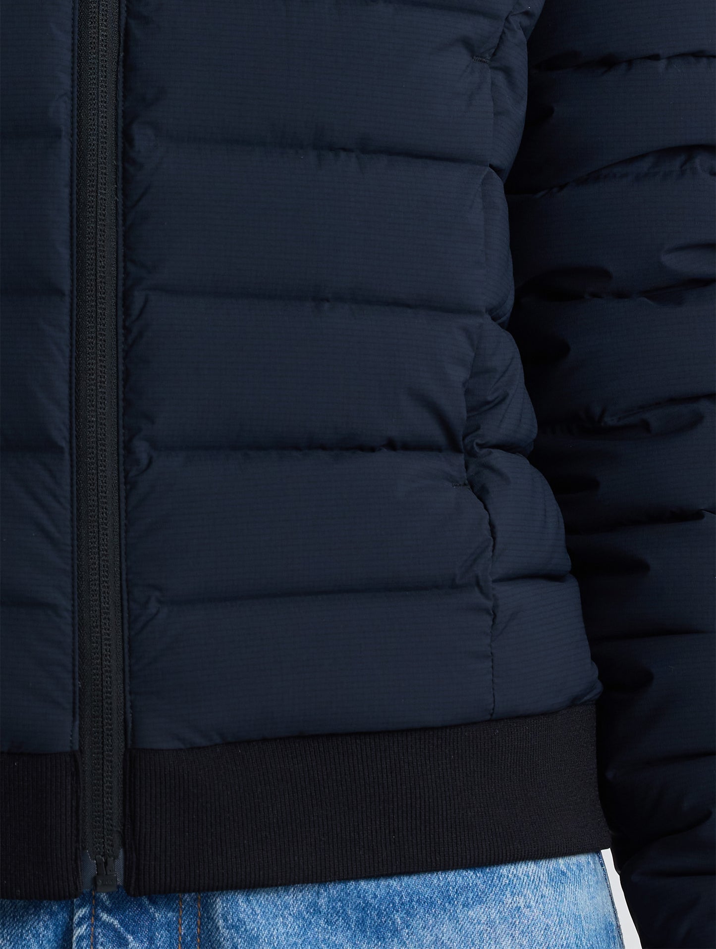 Closeup view of wearer's left pocket of W Launch Full-Zip Jacket NH in Onyx Black from AETHER Apparel.