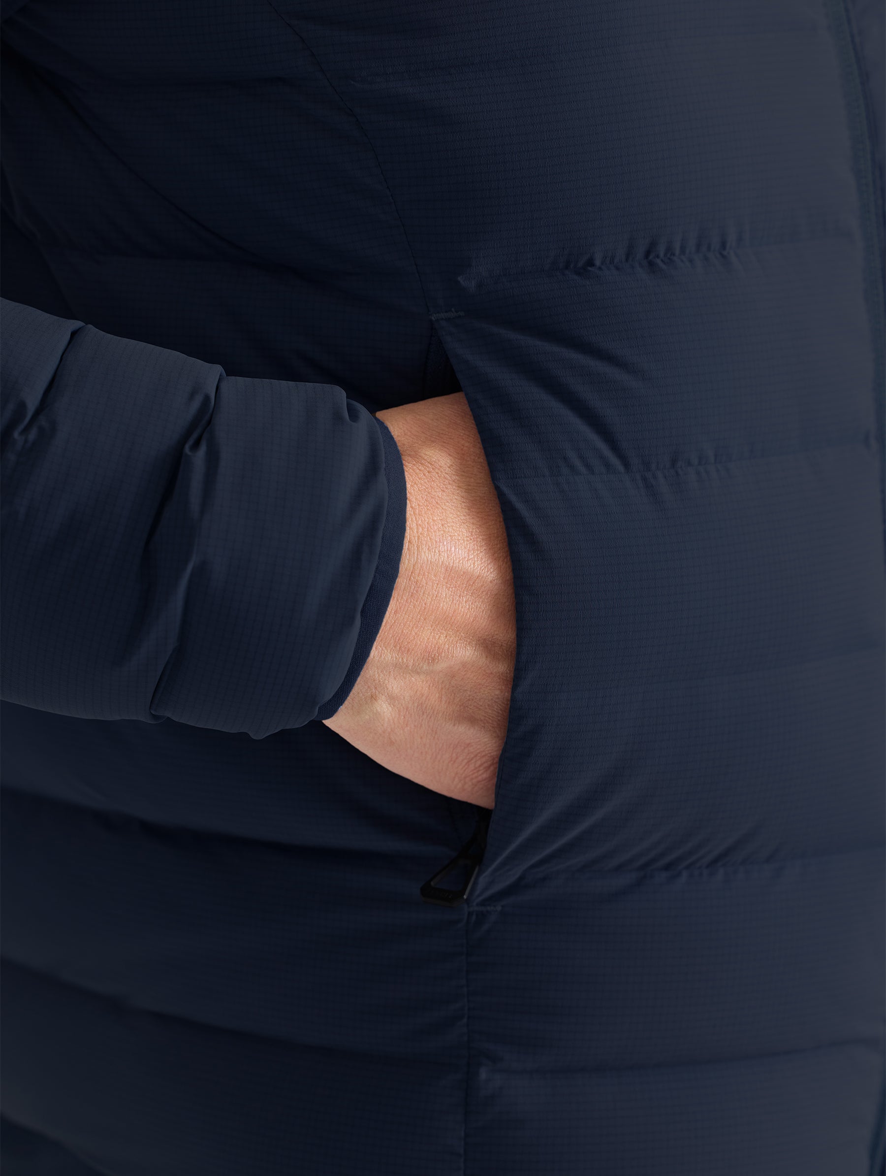 Closeup detail view of wearer's hand in right pocket of W Launch Full-Zip Jacket NH in Onyx Black from AETHER Apparel.