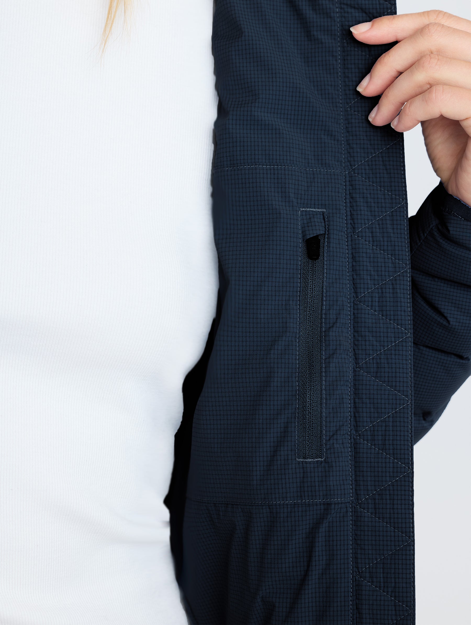 Closeup detail view of wearer's interior left pocket of W Launch Full-Zip Jacket NH in Onyx Black from AETHER Apparel.