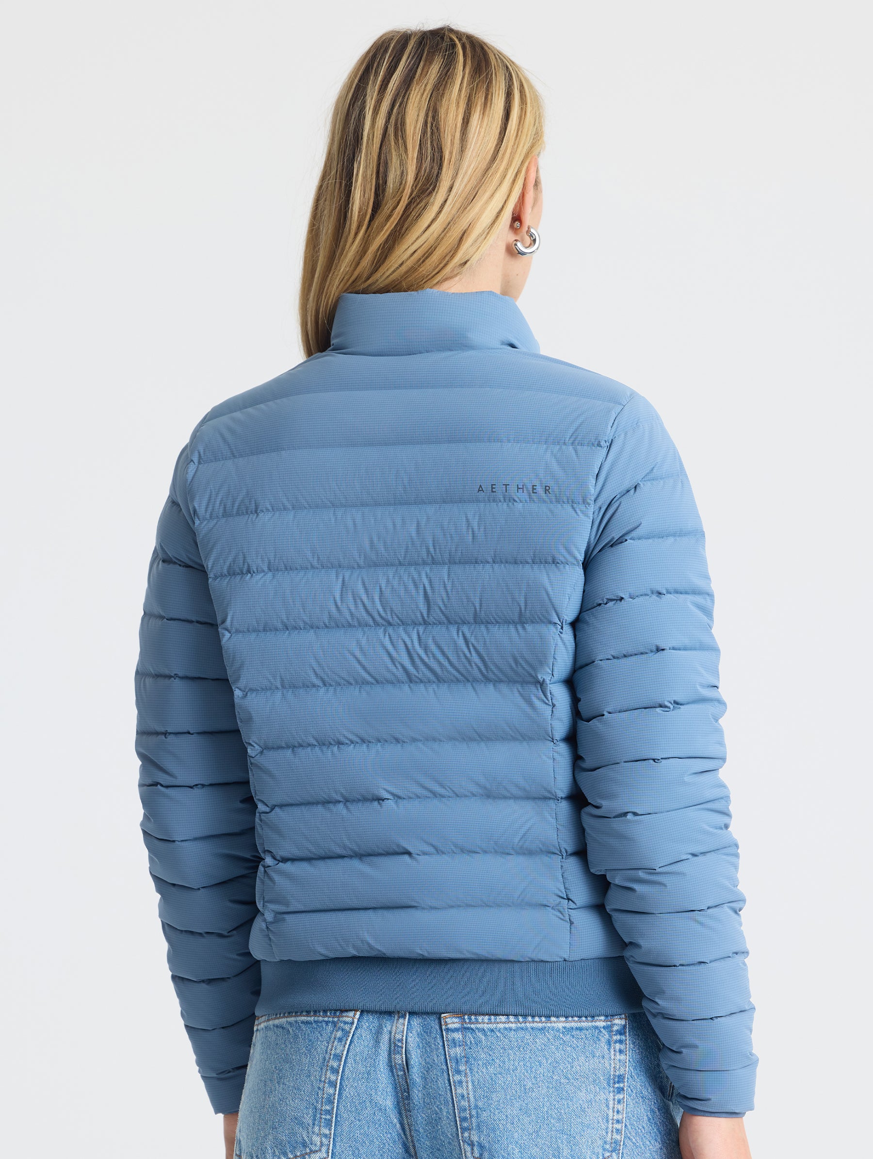 Rear  view of woman wearing W Launch Full-Zip Jacket NH in Portal Blue from AETHER Apparel.