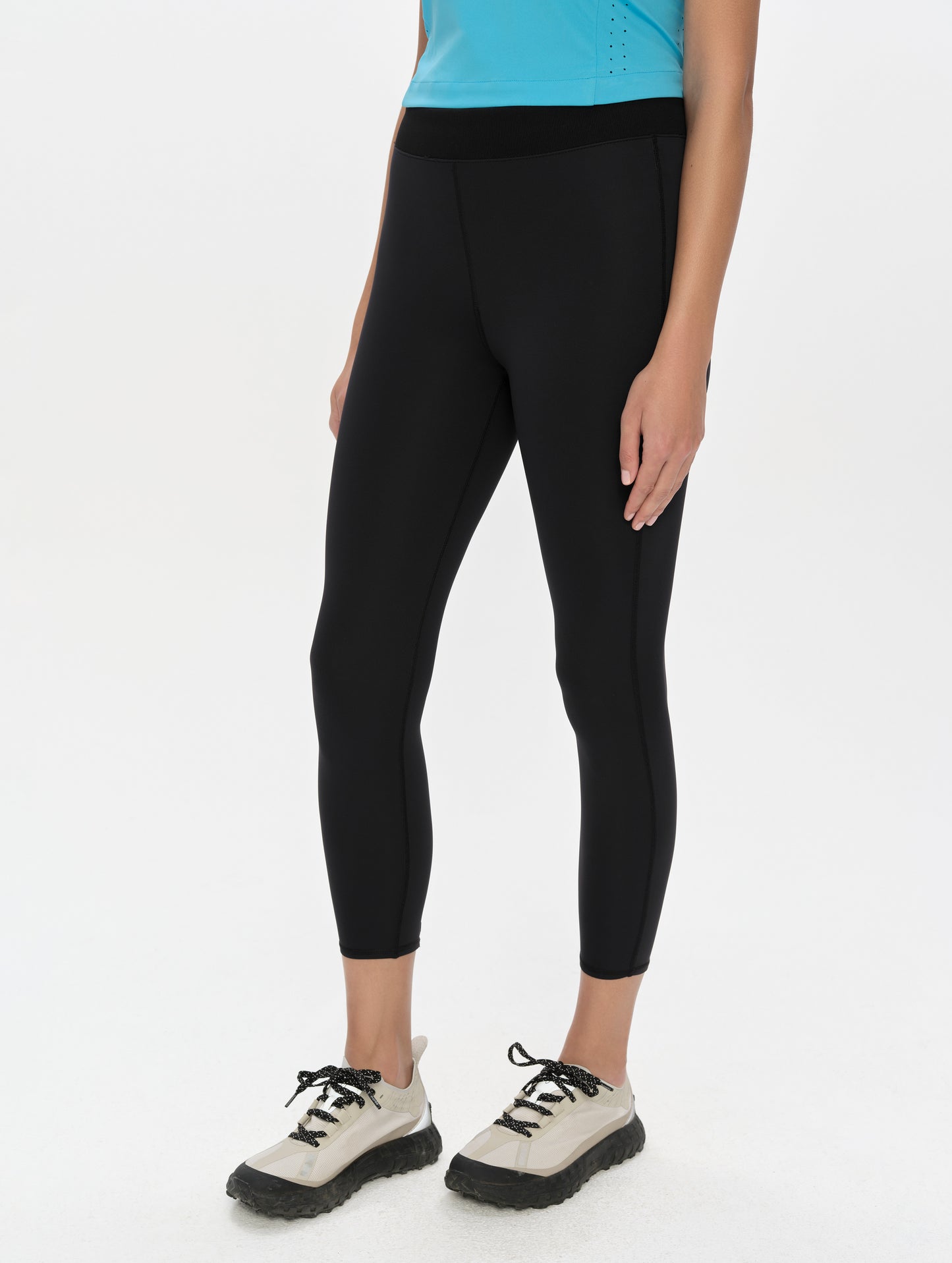 Front, 3/4, lower-body view of woman wearing the Laurel Legging in Onyx Black from AETHER Apparel.