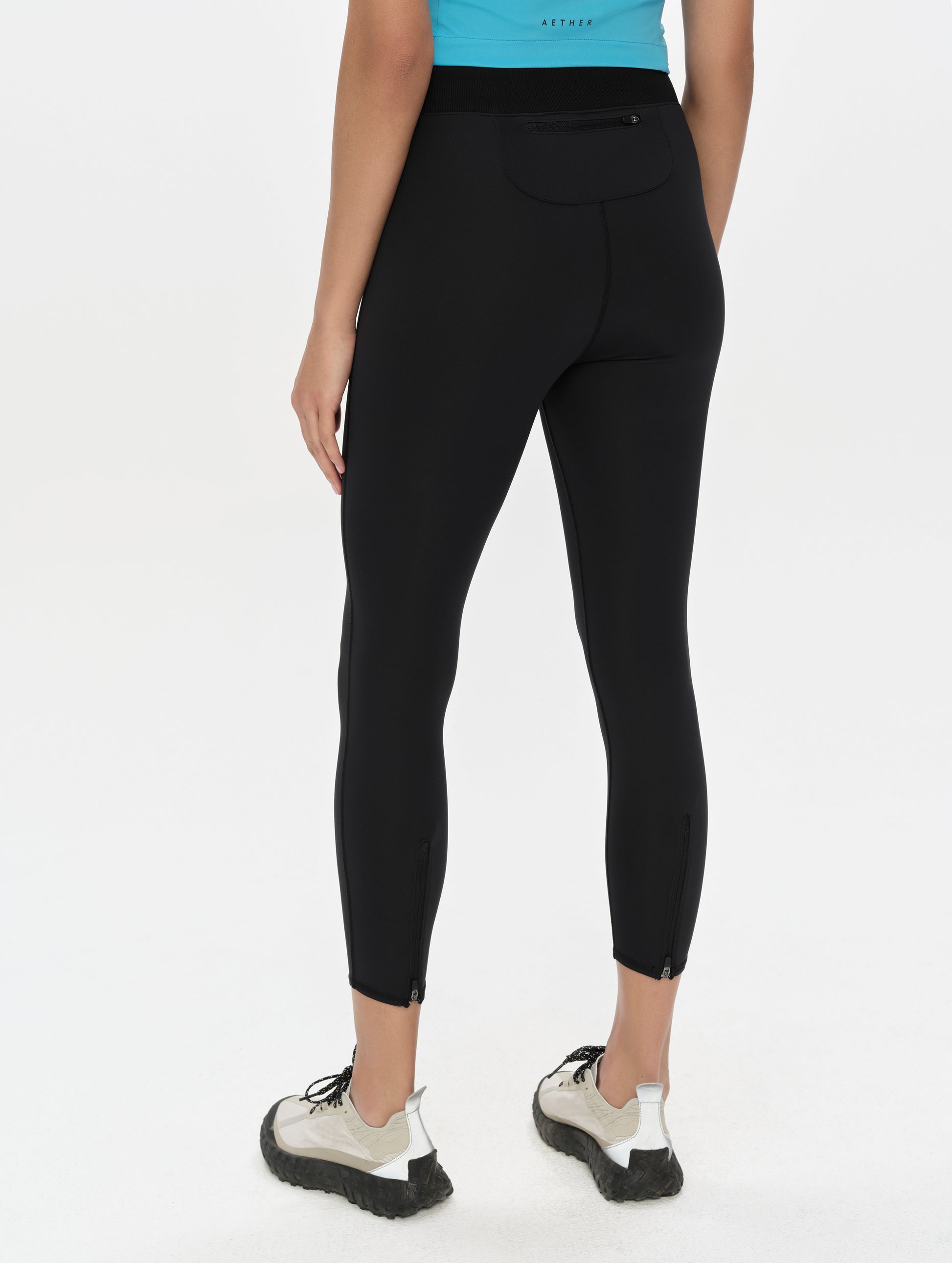 Rear, 3/4, lower-body view of woman wearing the Laurel Legging in Onyx Black from AETHER Apparel.