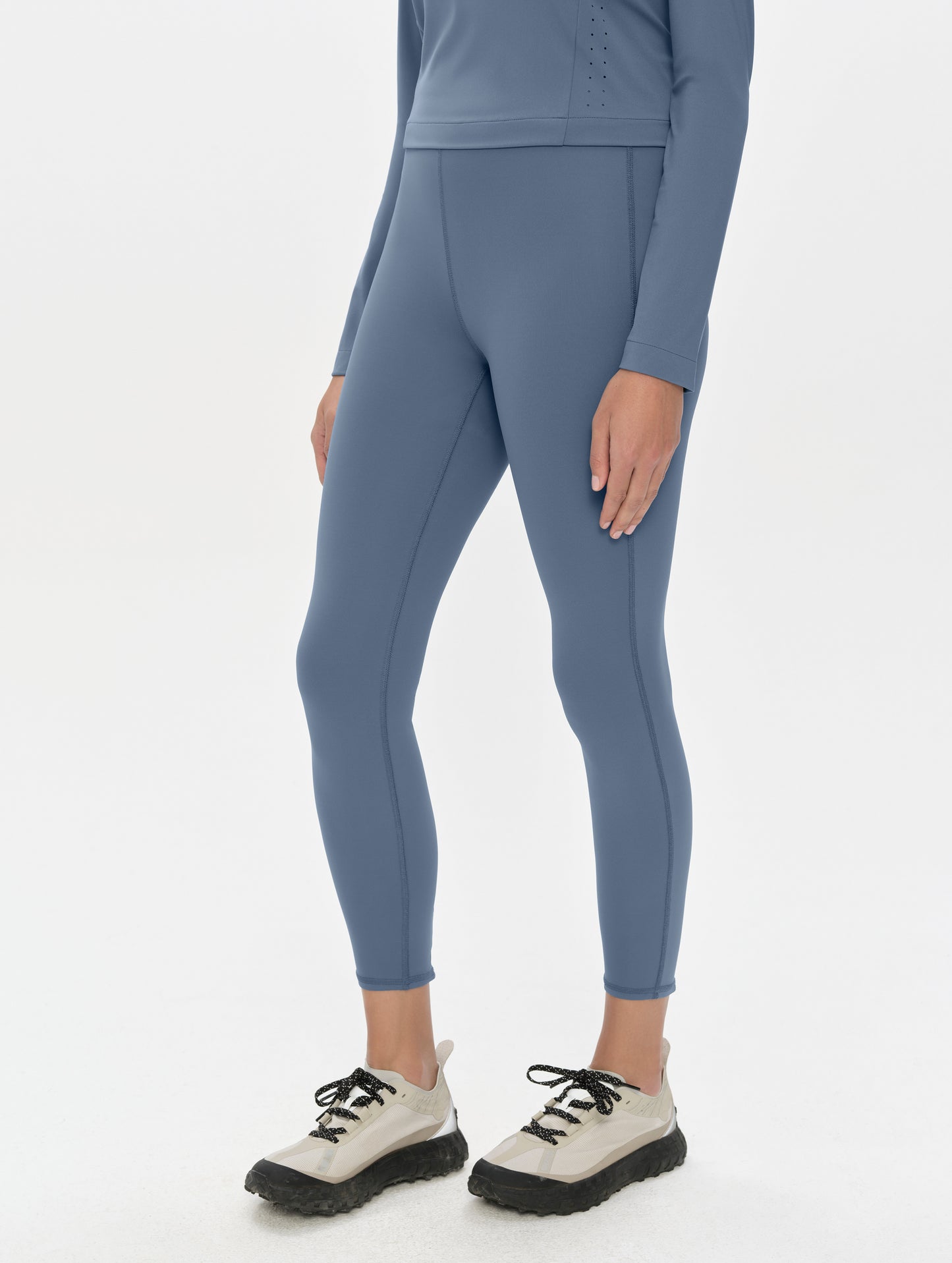 Front, 3/4, lower-body view of woman wearing the Laurel Legging in Portal Blue from AETHER Apparel.