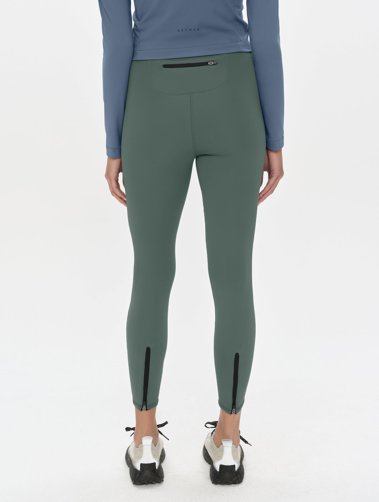 Rear, lower-body view of woman wearing the Laurel Legging in Saville Green from AETHER Apparel.