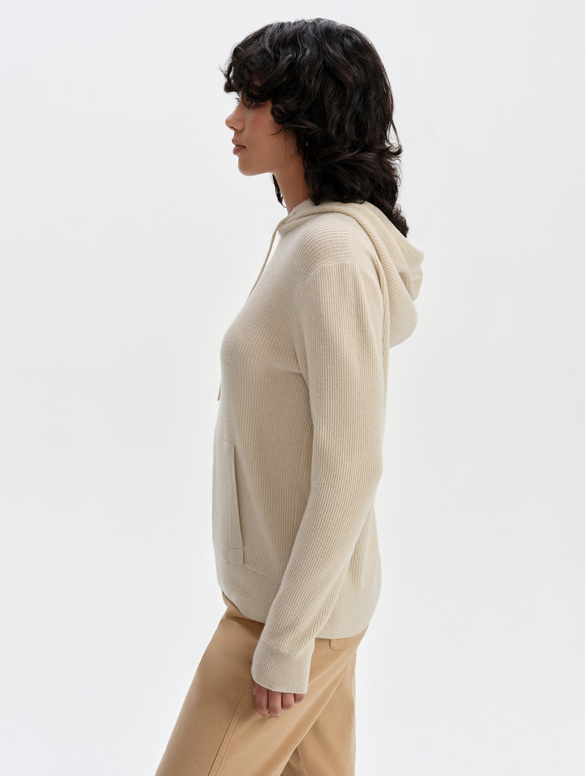 Side profile upper-body view of woman wearing the Lawrence Cashmere Hooded Sweater in Bone from AETHER Apparel.