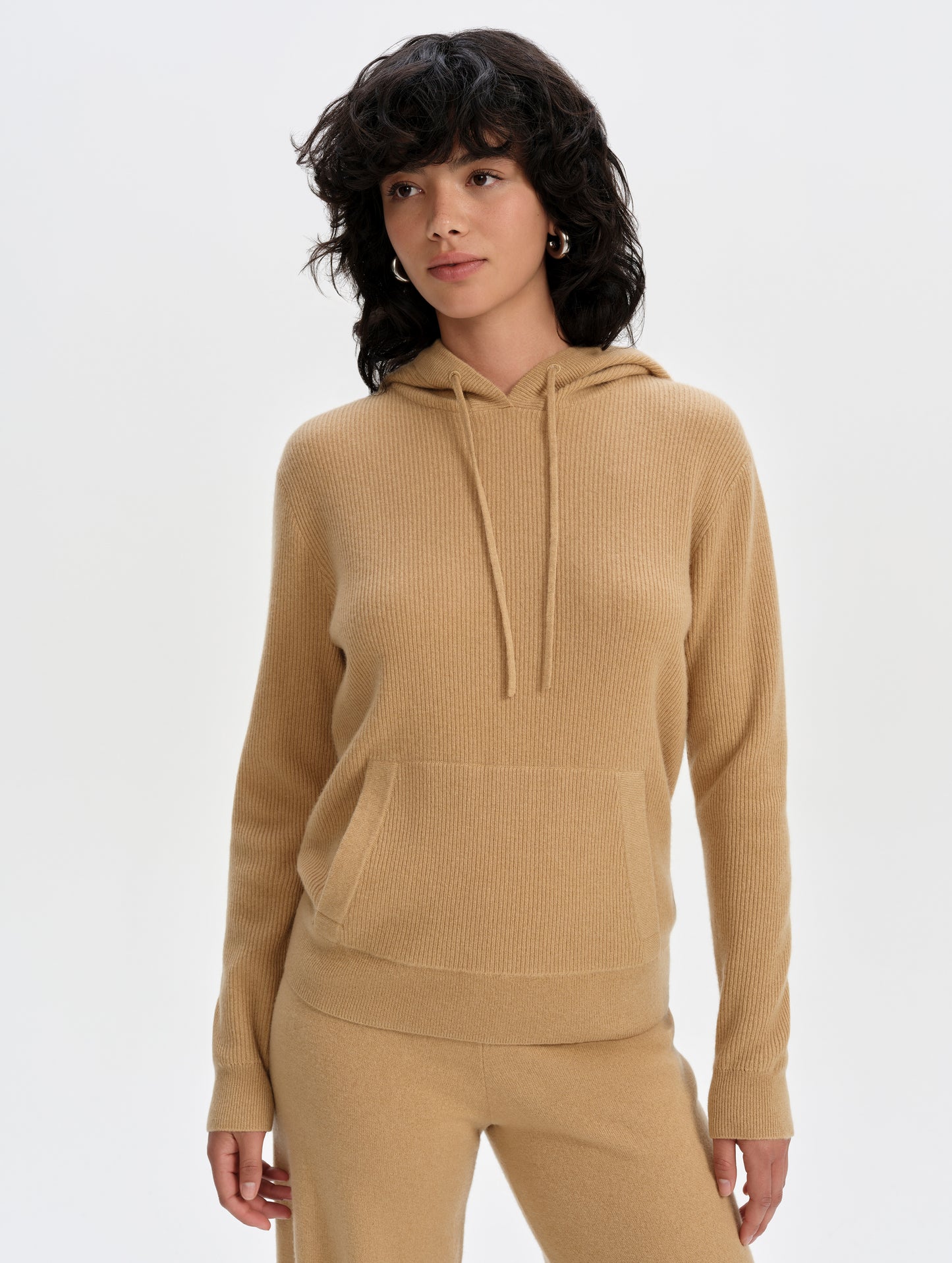 Front upper-body view of woman wearing the Lawrence Cashmere Hooded Sweater in Latte Brown from AETHER Apparel.