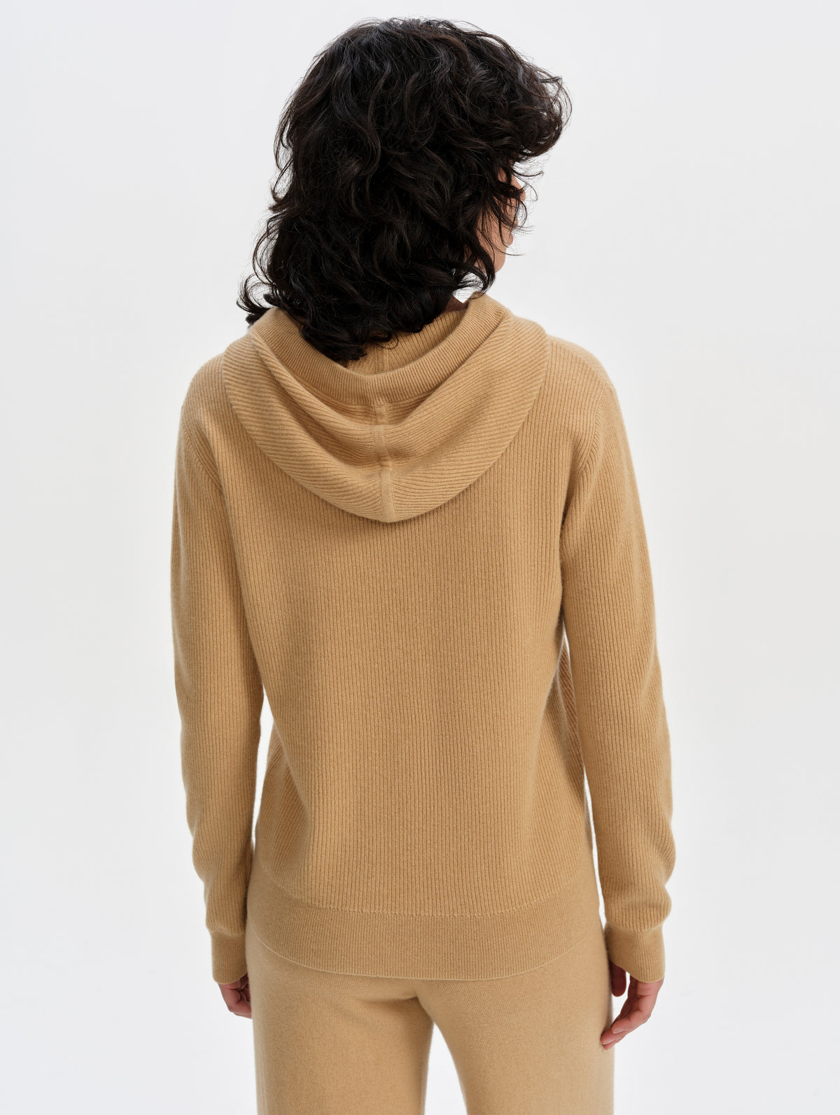 Rear upper-body view of woman wearing the Lawrence Cashmere Hooded Sweater in Latte Brown from AETHER Apparel.