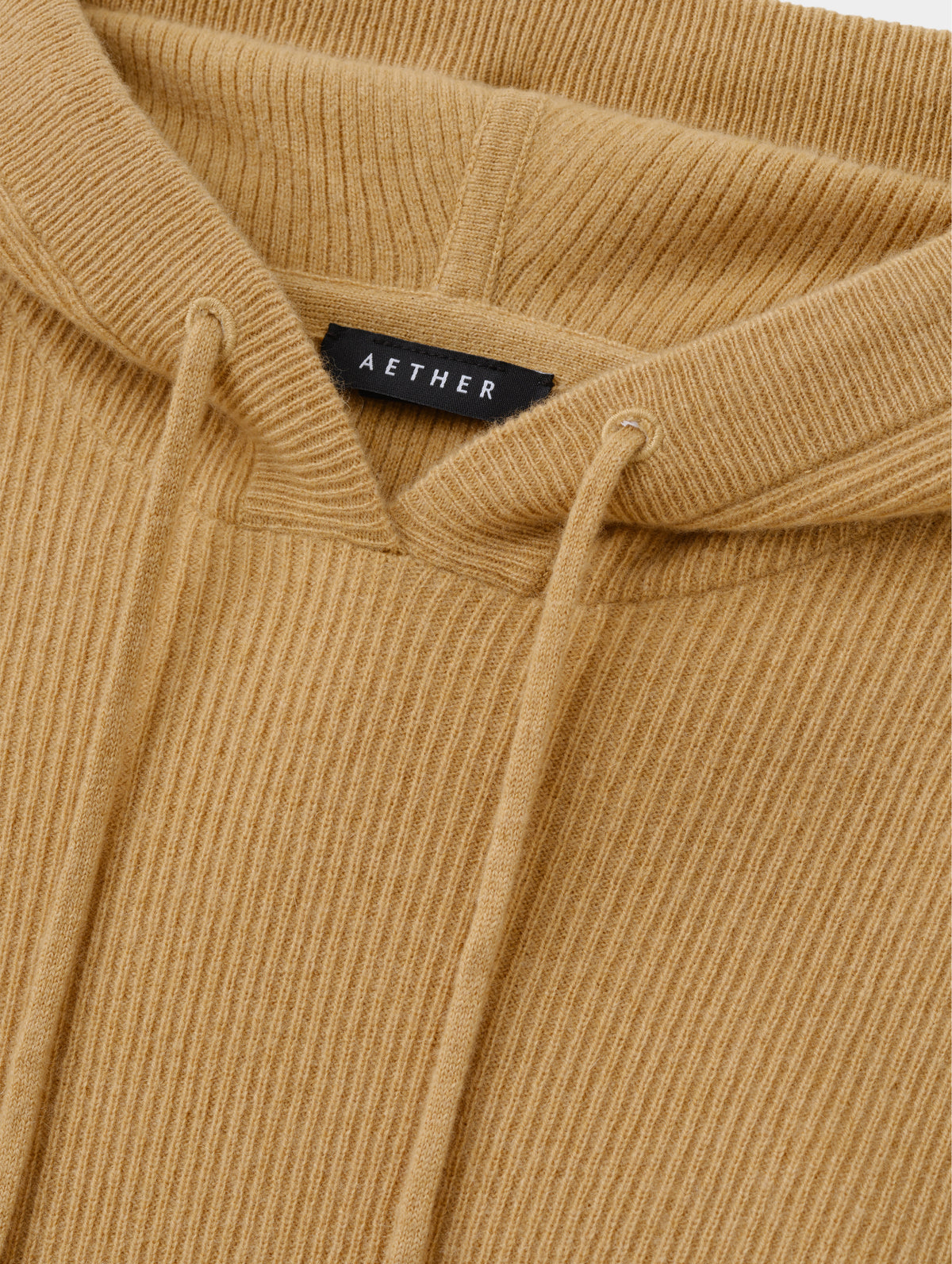 Closeup detailed view of the drawcord on the hood of the Lawrence Cashmere Hooded Sweater in Latte Brown from AETHER Apparel.