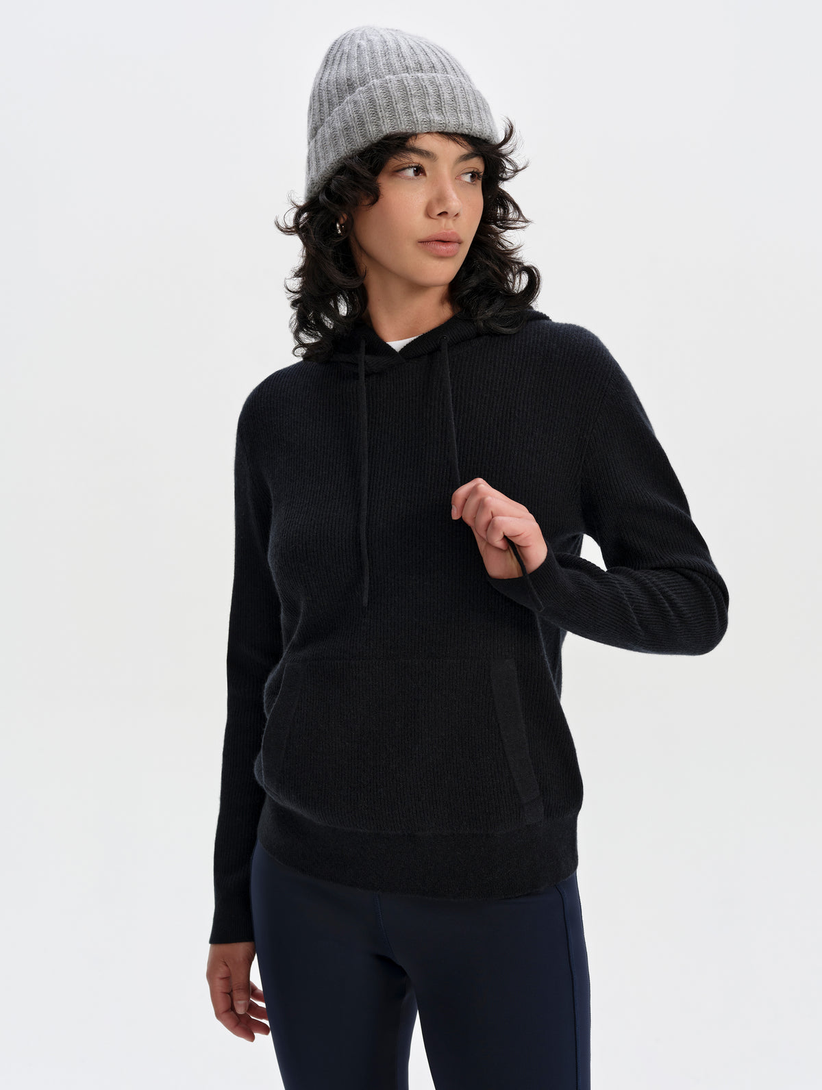 Front upper-body view of woman wearing the Lawrence Cashmere Hooded Sweater in Onyx Black from AETHER Apparel.