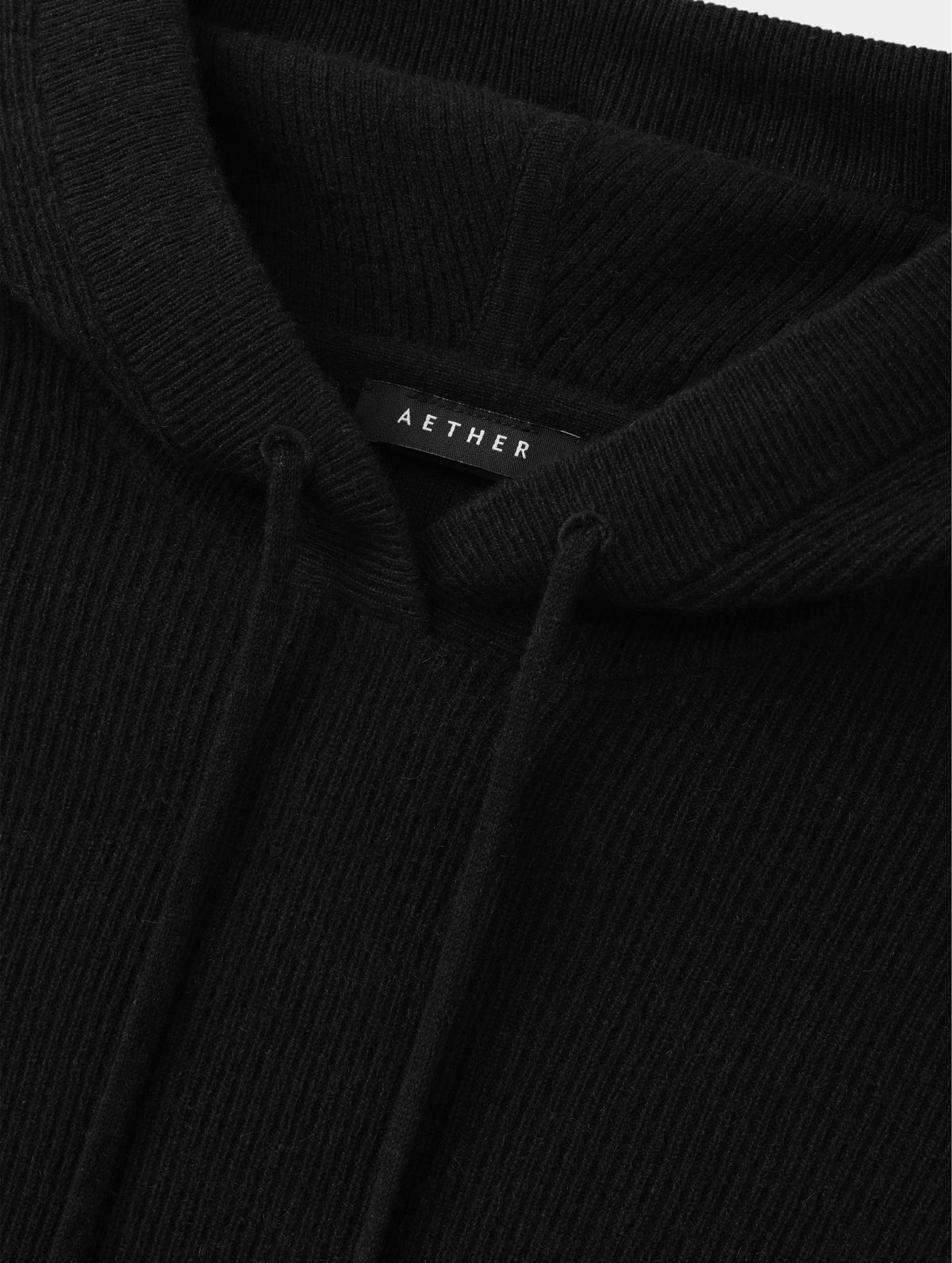 Closeup detailed view of the drawcord on the hood of the Lawrence Cashmere Hooded Sweater in Onyx Black from AETHER Apparel.