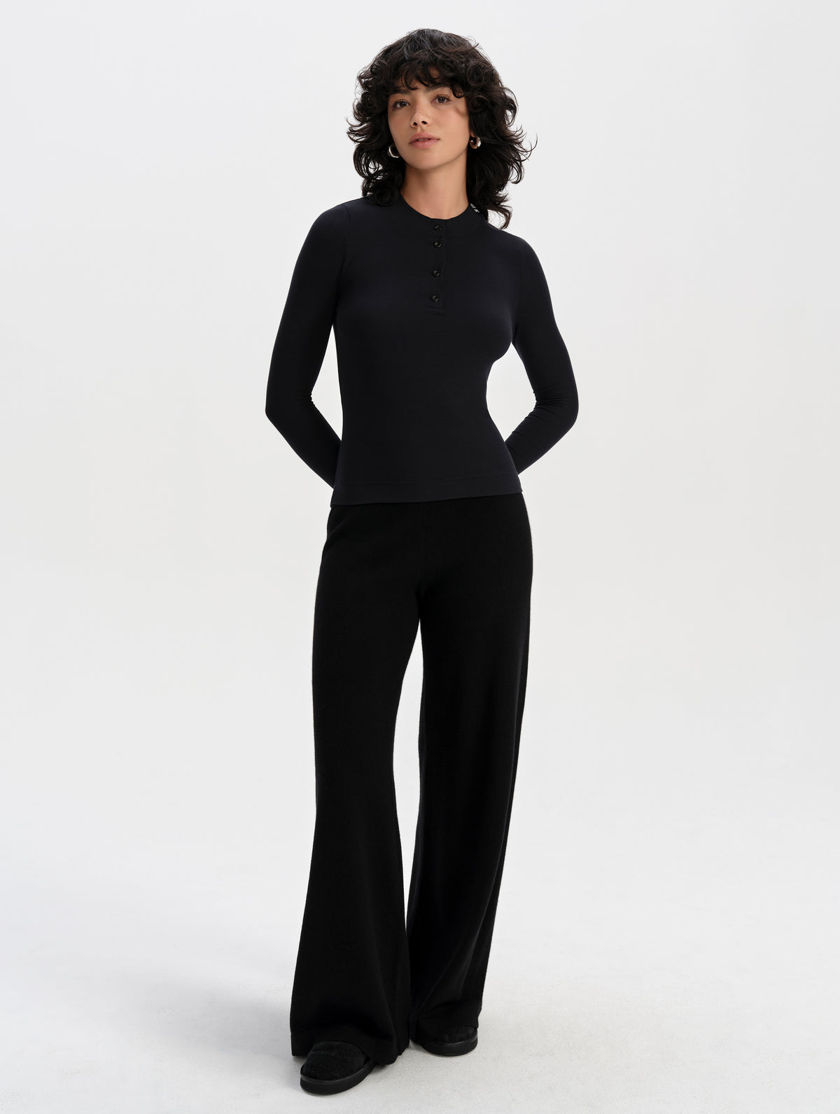 Front full-body view of woman wearing the Legacy Long-Sleeve Henley in Onyx Black from AETHER Apparel.