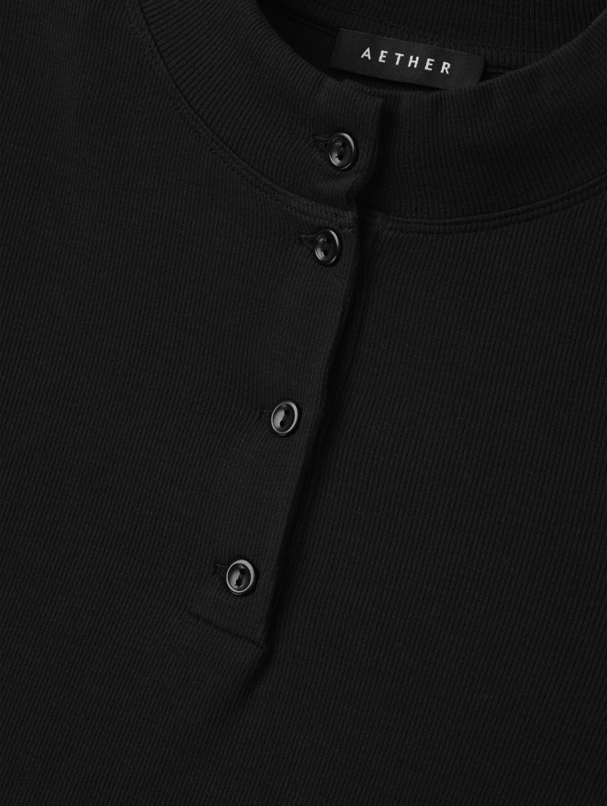 Closeup detailed view of the buttons on the Legacy Long-Sleeve Henley in Onyx Black from AETHER Apparel.