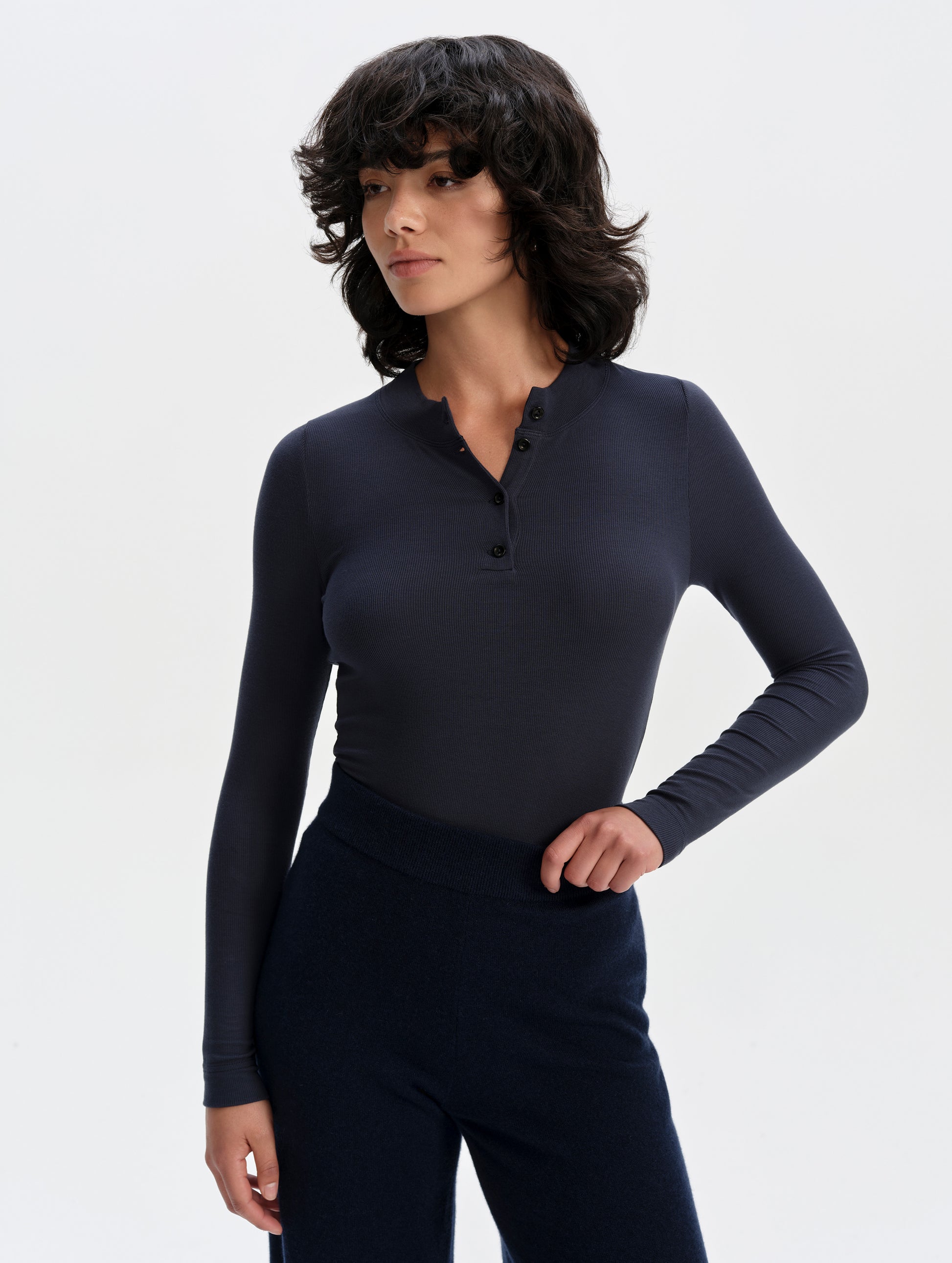 Front upper-body view of woman wearing the Legacy Long-Sleeve Henley in Total Eclipse from AETHER Apparel.