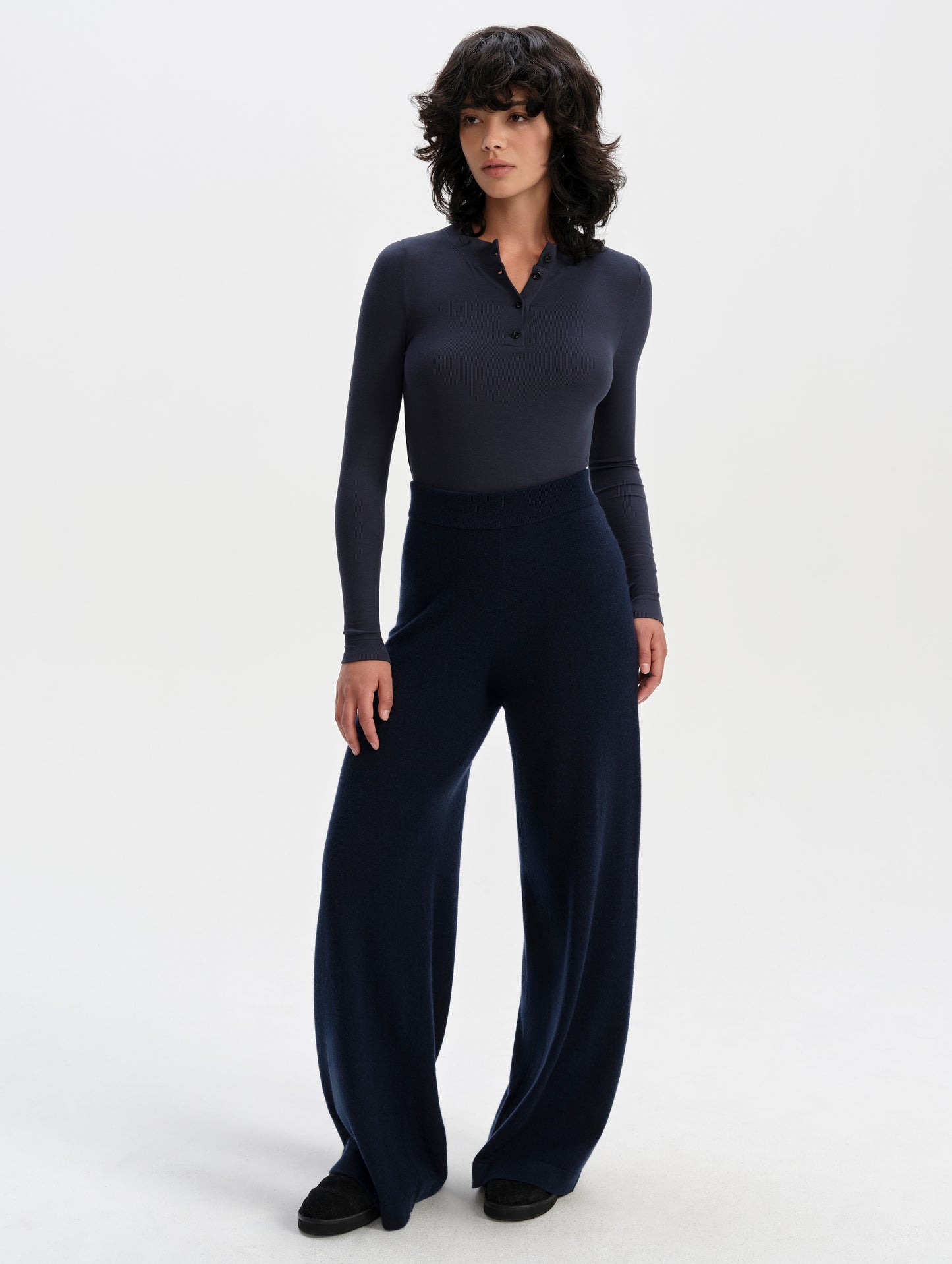 Front full-body view of woman wearing the Legacy Long-Sleeve Henley in Total Eclipse from AETHER Apparel.
