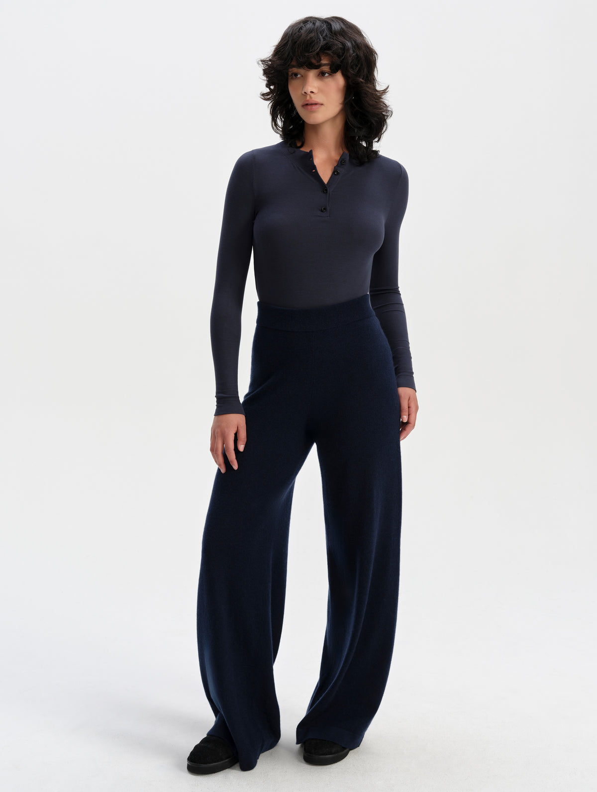 Front full-body view of woman wearing the Legacy Long-Sleeve Henley in Total Eclipse from AETHER Apparel.