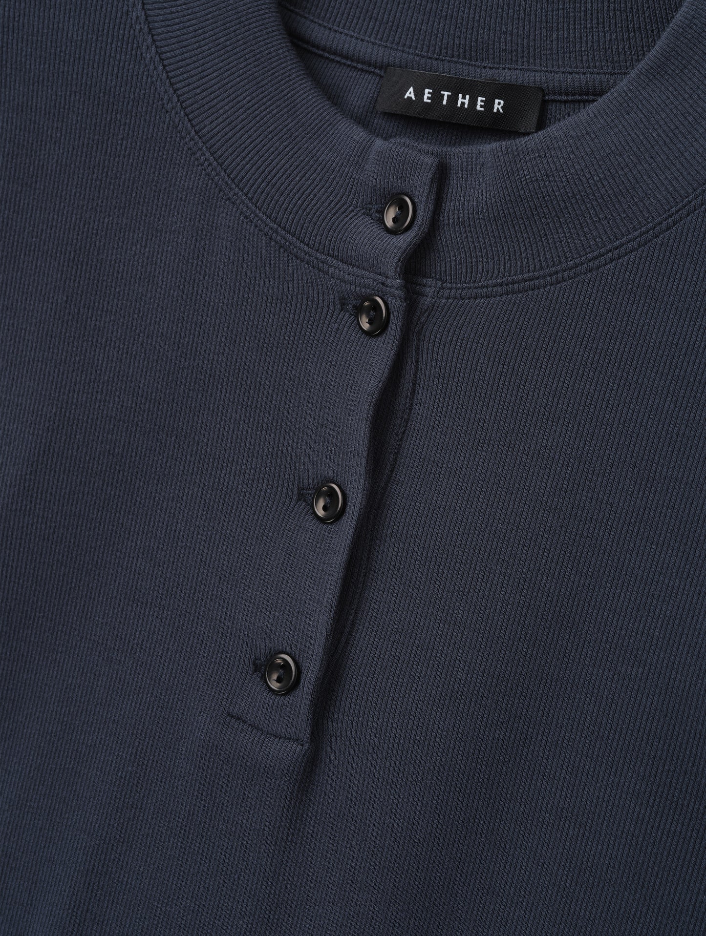 Closeup detailed view of the rib-knit fabric on the Legacy Long-Sleeve Henley in Total Eclipse from AETHER Apparel.