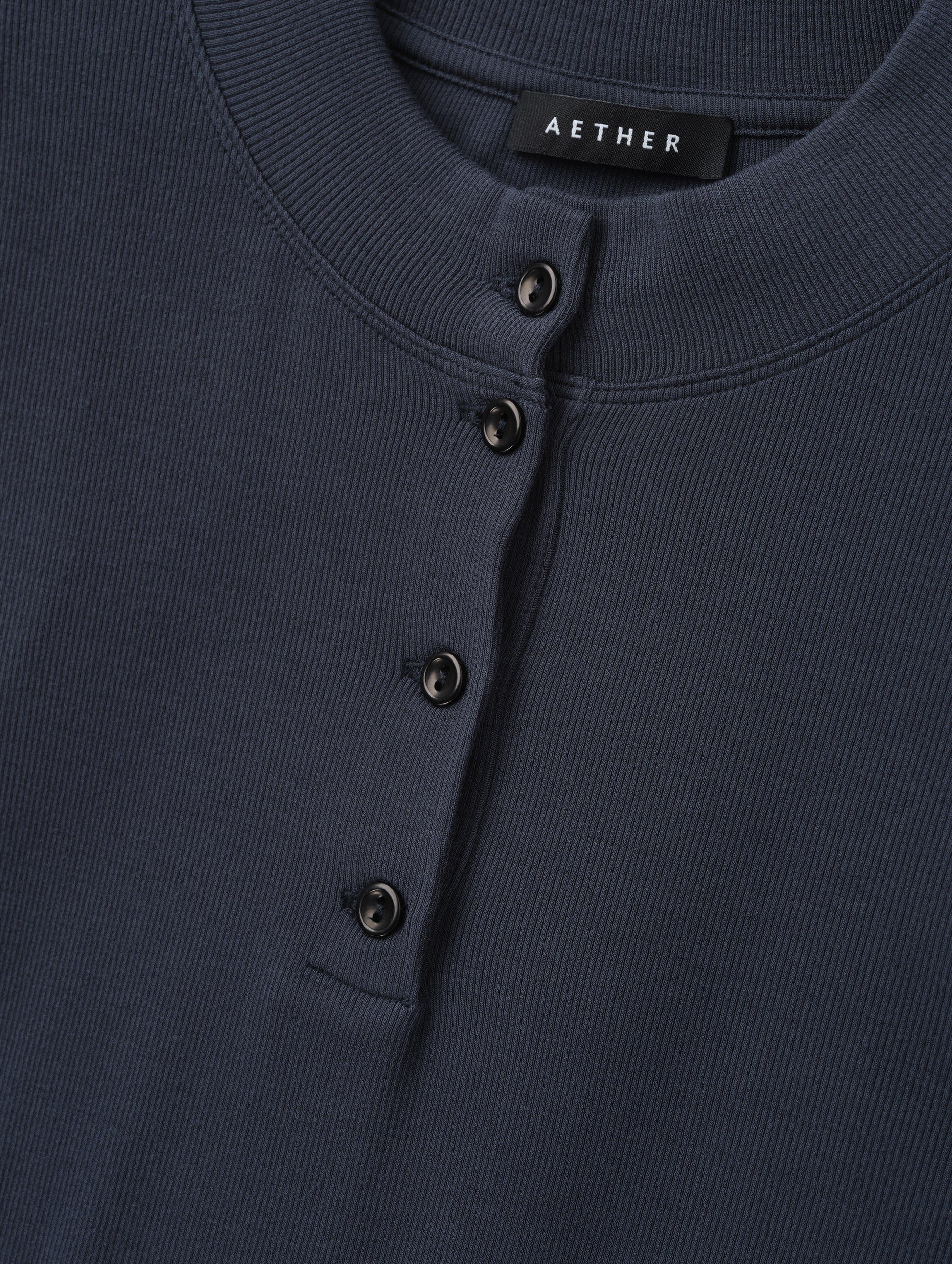 Closeup detailed view of the rib-knit fabric on the Legacy Long-Sleeve Henley in Total Eclipse from AETHER Apparel.