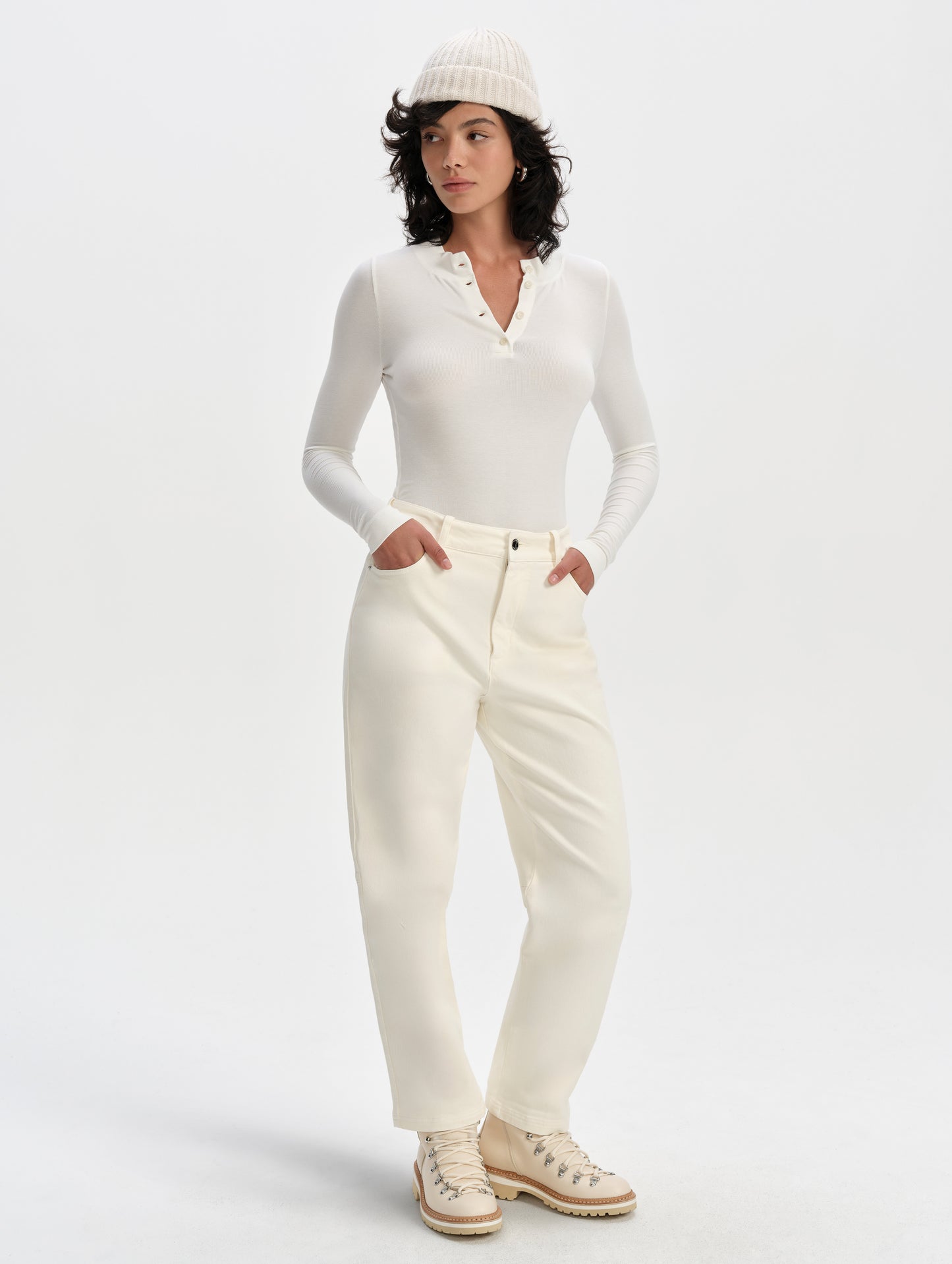 Front full-body view of woman wearing the Legacy Long-Sleeve Henley in Winter White from AETHER Apparel.