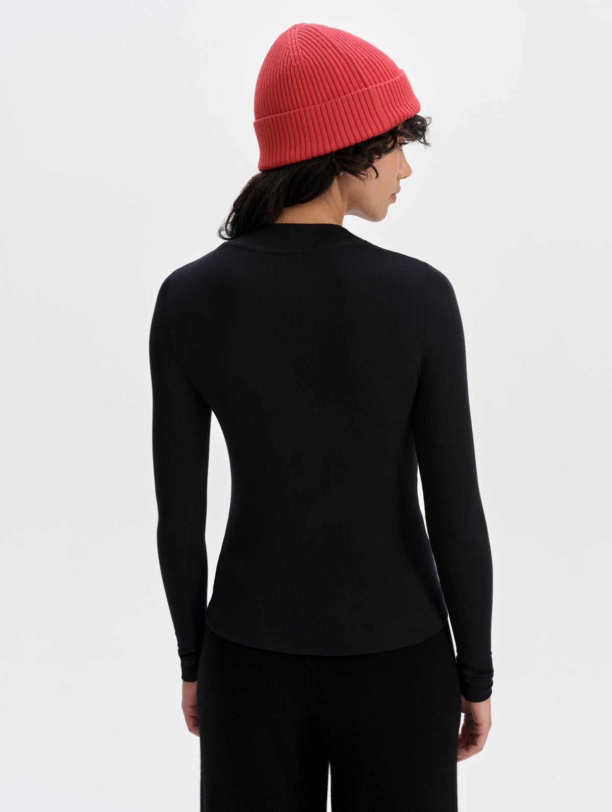 Rear upper-body view of woman wearing the Legacy Long-Sleeve Shirt in Winter White from AETHER Apparel.