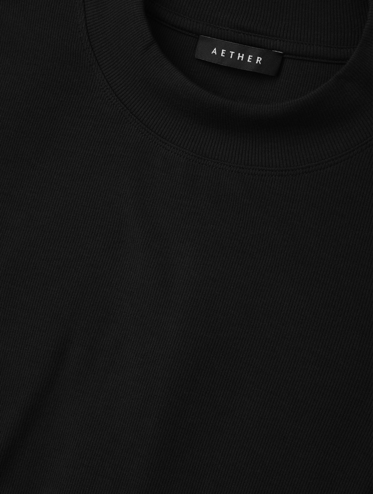 Closeup detailed view of the rib-knit fabric on the Legacy Long-Sleeve Shirt in Onyx Black from AETHER Apparel.